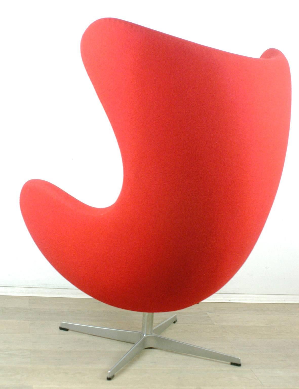 Iconic Jacobsens egg chair designed 1958 with original red wool fabric, four star base, swiveling and reclining function.