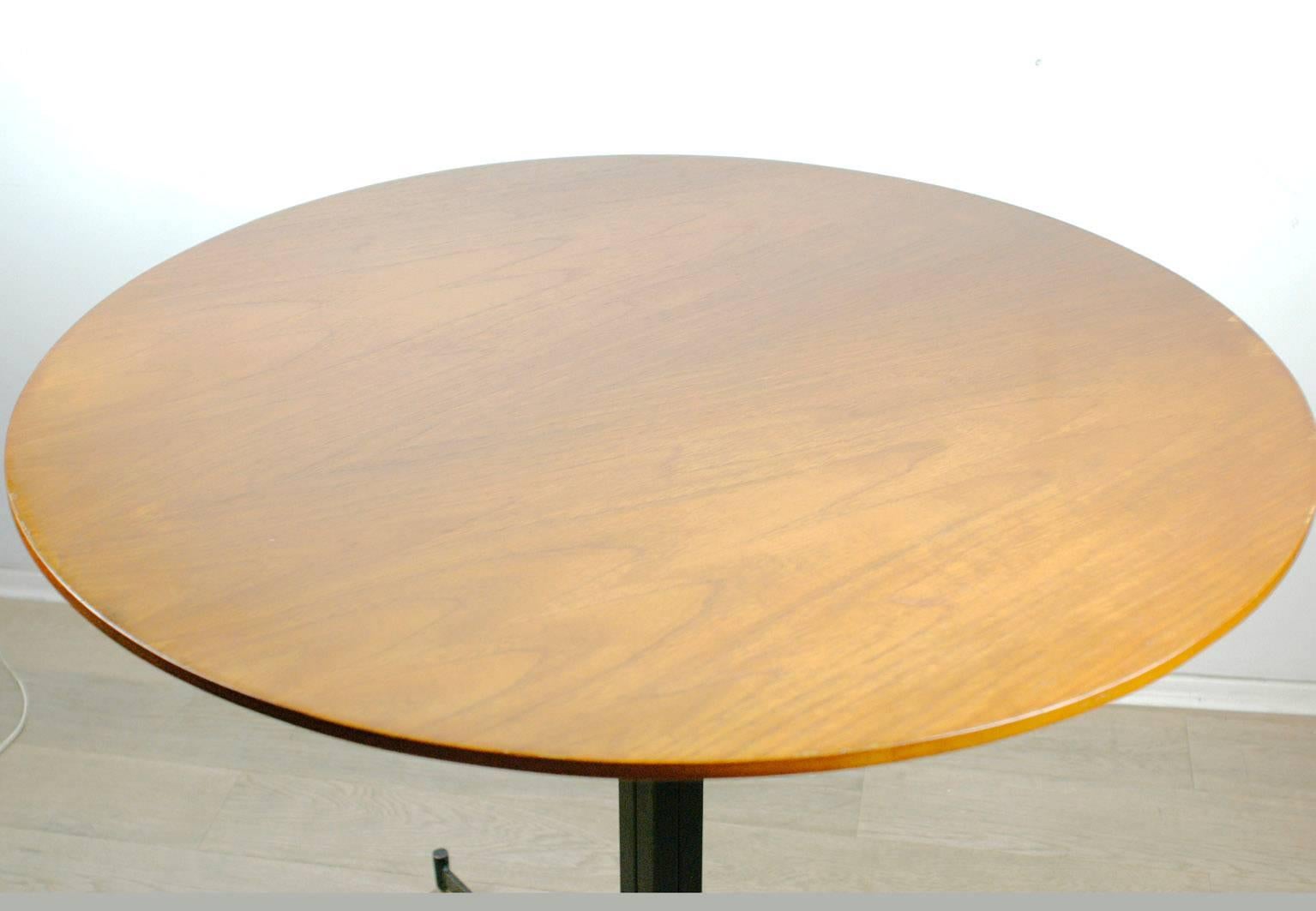 Small elegant Italian Midcentury circular table for four-five persons.
Teakwood top with black laquered metal and brass base.