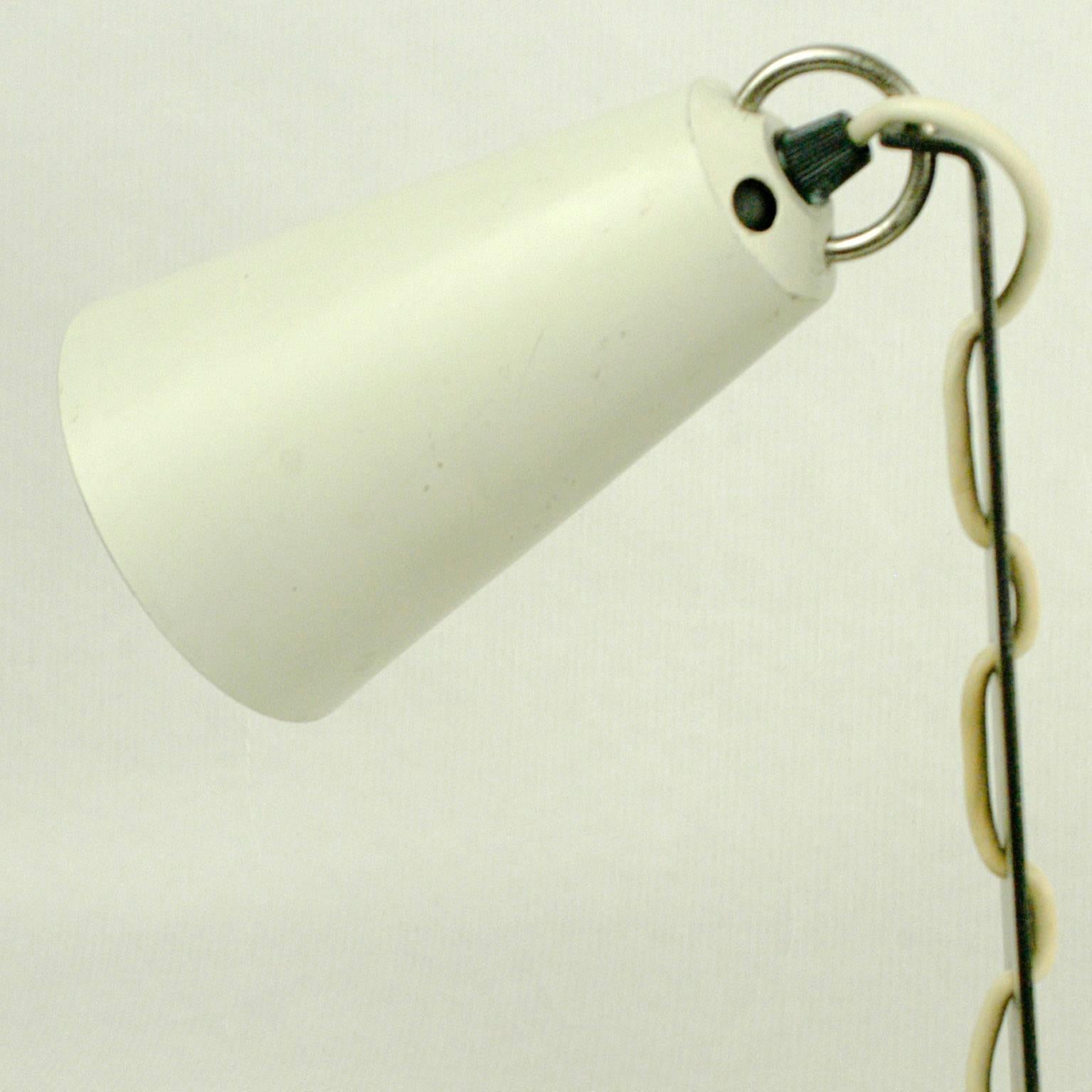 Este Raro y encantador  Lámpara de mesa austriaca de mediados de siglo, Model No. 1246, fue diseñada y fabricada por J.T. Kalmar Viena en la década de 1960.
Presenta una pantalla ajustable lacada en blanco y una base negra, todo ello en muy buen