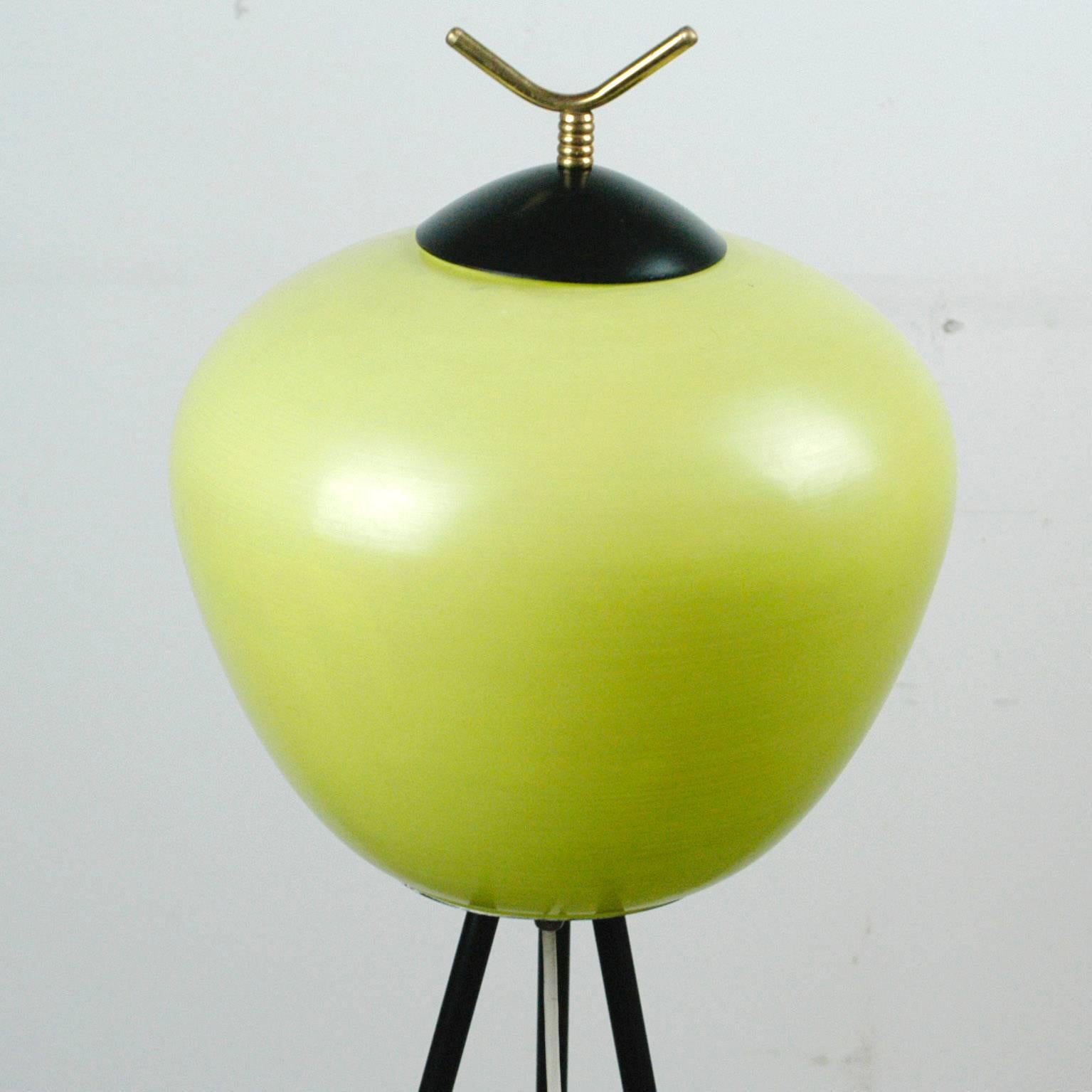 This charming and elegant Italian Midcentury Floorlamp has been manufactured by Stilnovo and features a brass and black lacquered tripod base with a yellow  green glass shade. It is in beautiful condition, in fully working order and has two E14