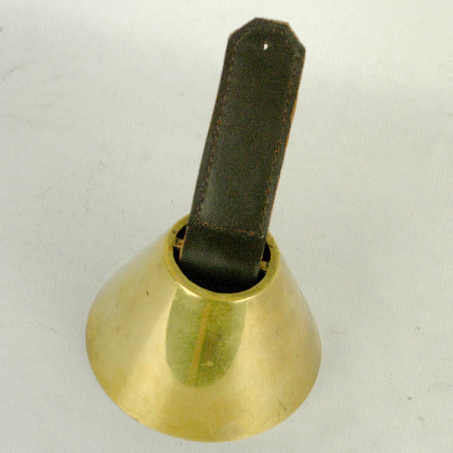 Austrian midcentury brass and leather bell by Designer and Architect Carl Auböck.
The leather has been renewed.