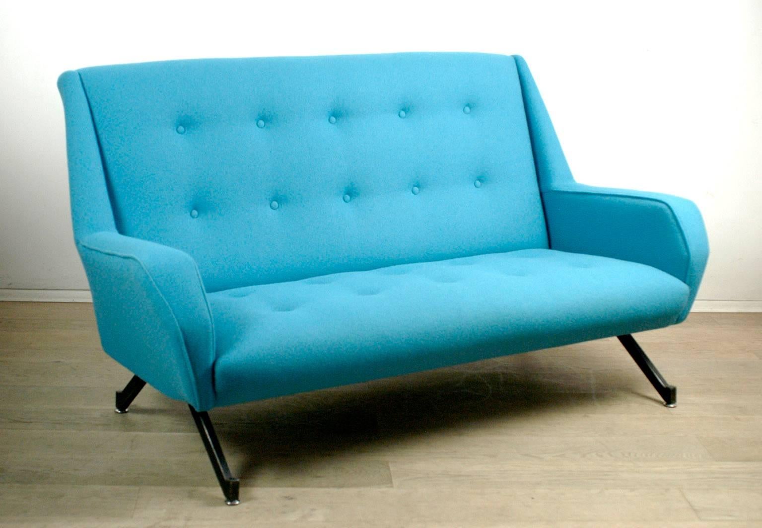 Charming Italian and original from the 1950s sofa or sette. It features black laquered tapering metal legs and has been internally completely restored and upholstered with top quality new blue Kvadrat fabric, the back with ten buttons. With its