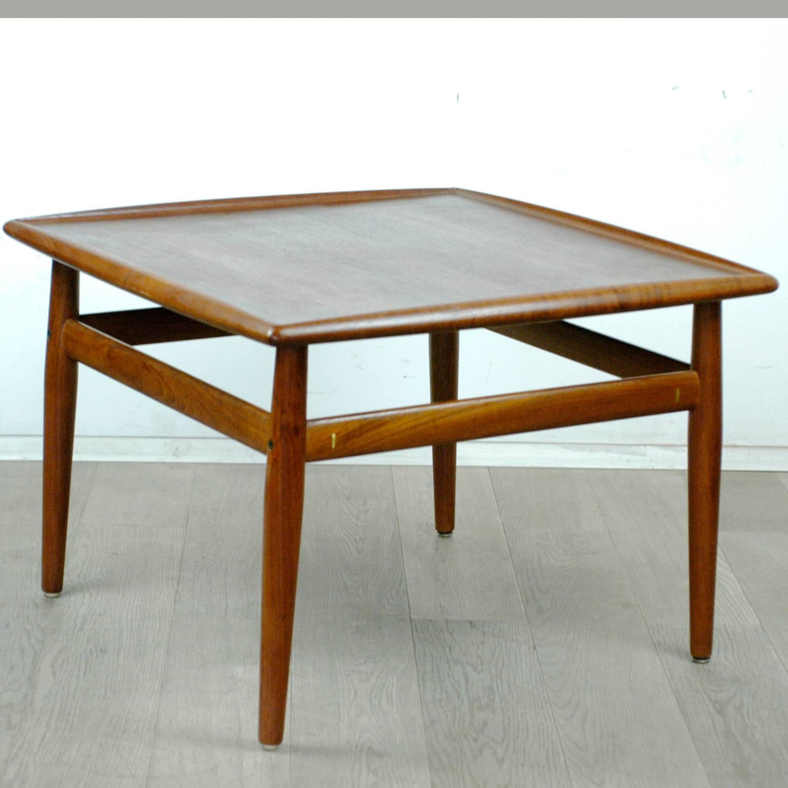 Excellent handcrafted Scandinavian Modern teak coffee table designed by Grete Jalk, with brass details, tabletop with beautiful grain.