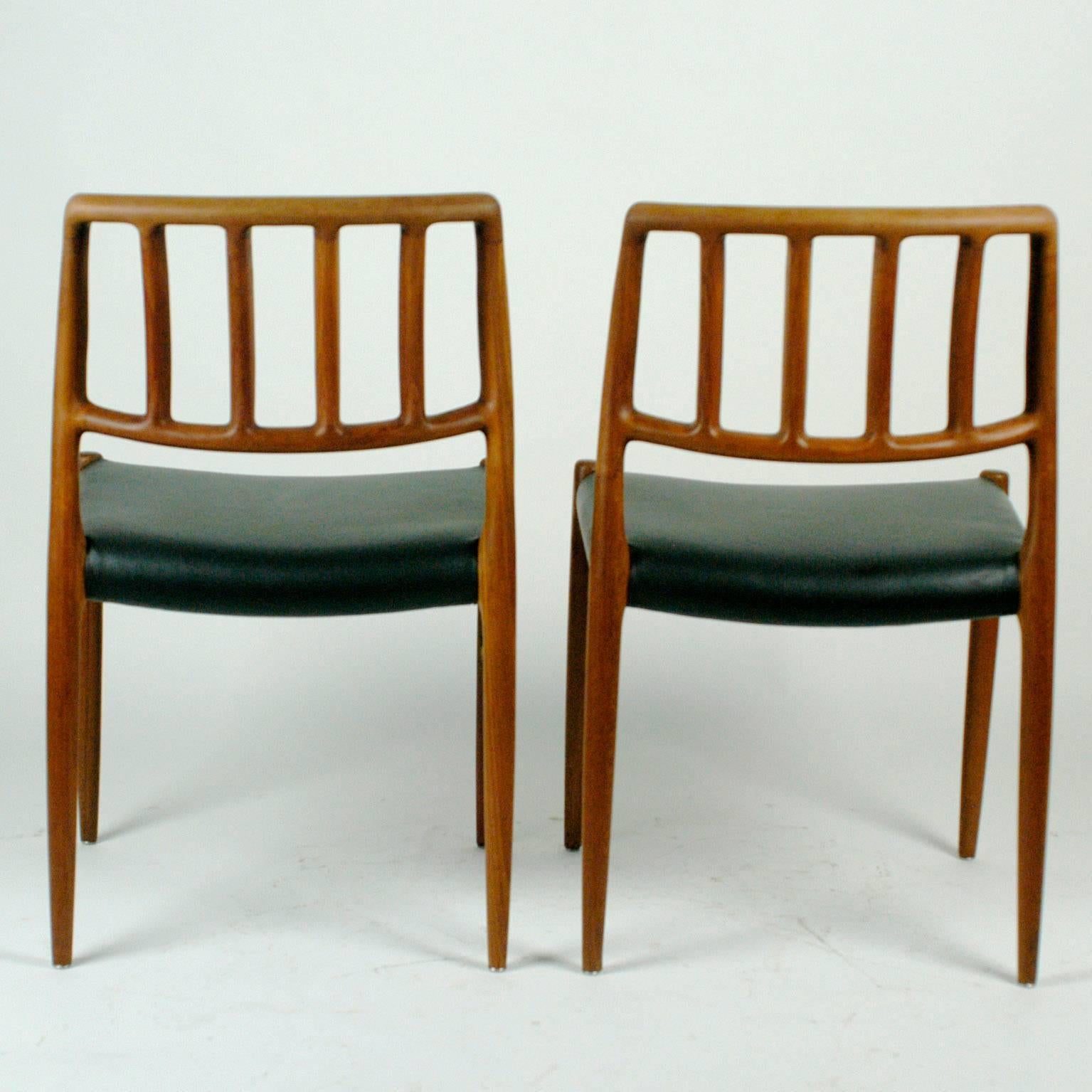 Two sculptural Danish teak dining chairs with black leather seats designed by Niels Otto Möller in the early 70s. 
Born in 1920 in Aarhus Denmark Moller is famous for his excellent designs and craftmenship of furniture He founded his own manufactury