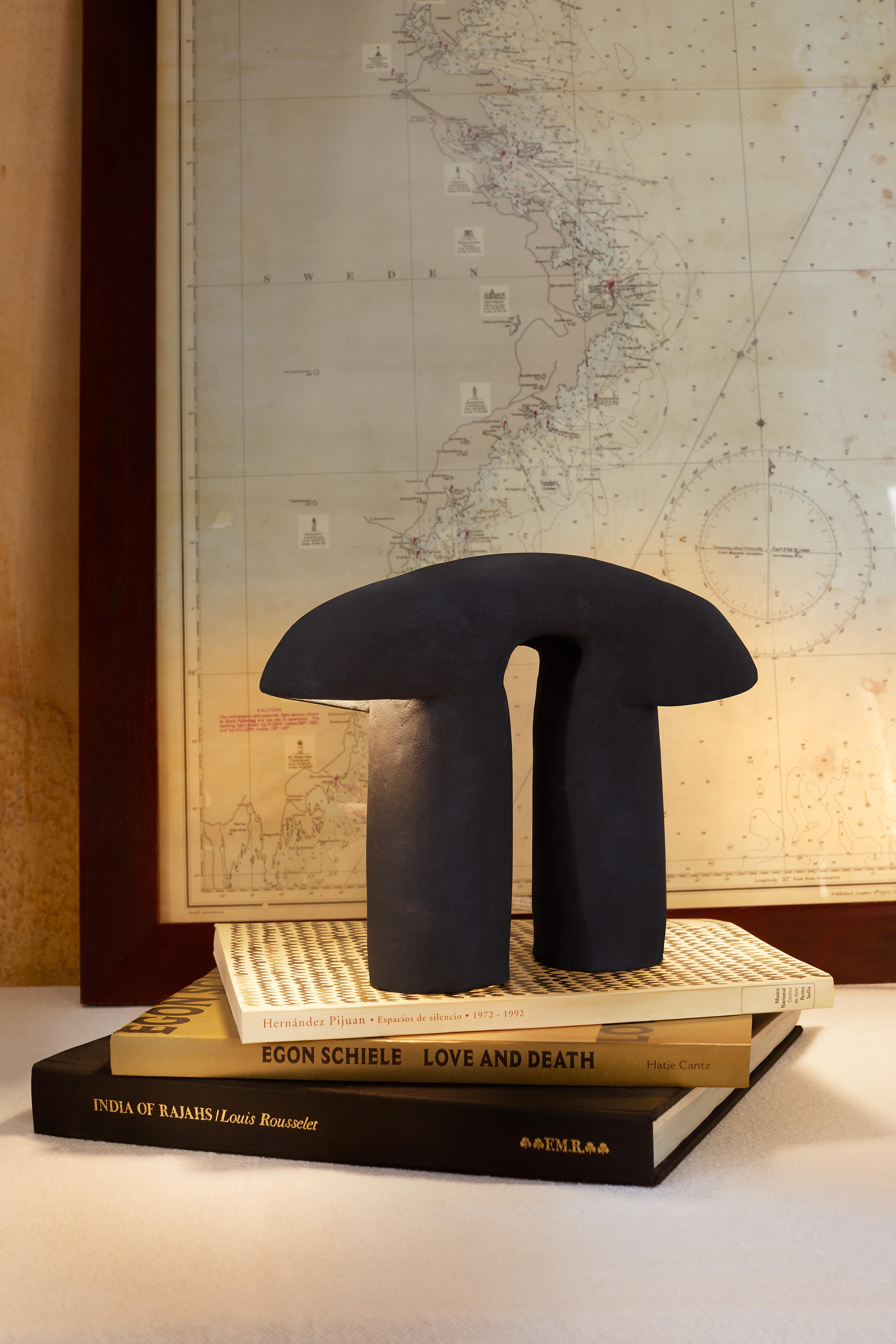 Pi ist eine Lampen-Skulptur, die von Irene Sánchez Carrillo in ihrem Studio in Barcelona von Hand modelliert wurde. Hergestellt aus schwarzem Schamotte-Steinzeug mit matter Oberfläche,  Die erdige Textur und die schlichte Silhouette erinnern an die