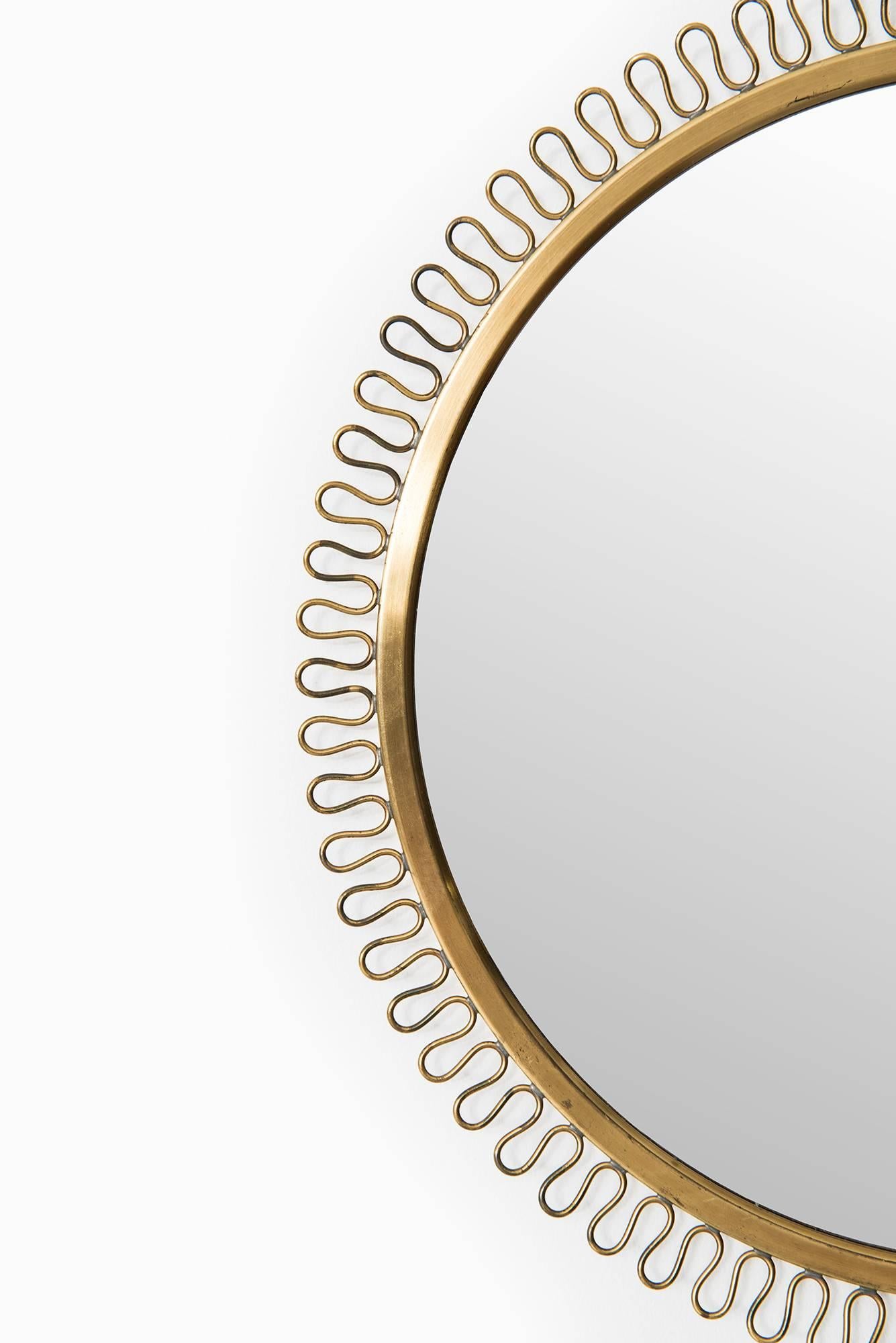 Round mirror in brass designed by Josef Frank. Produced by Svenskt Tenn in Sweden.