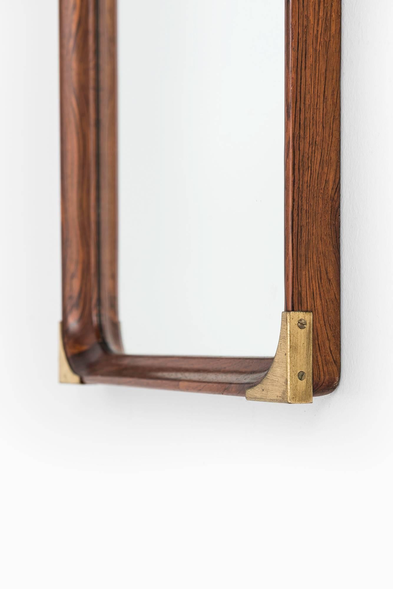 Rare mirror in rosewood with brass details. Produced in Sweden.