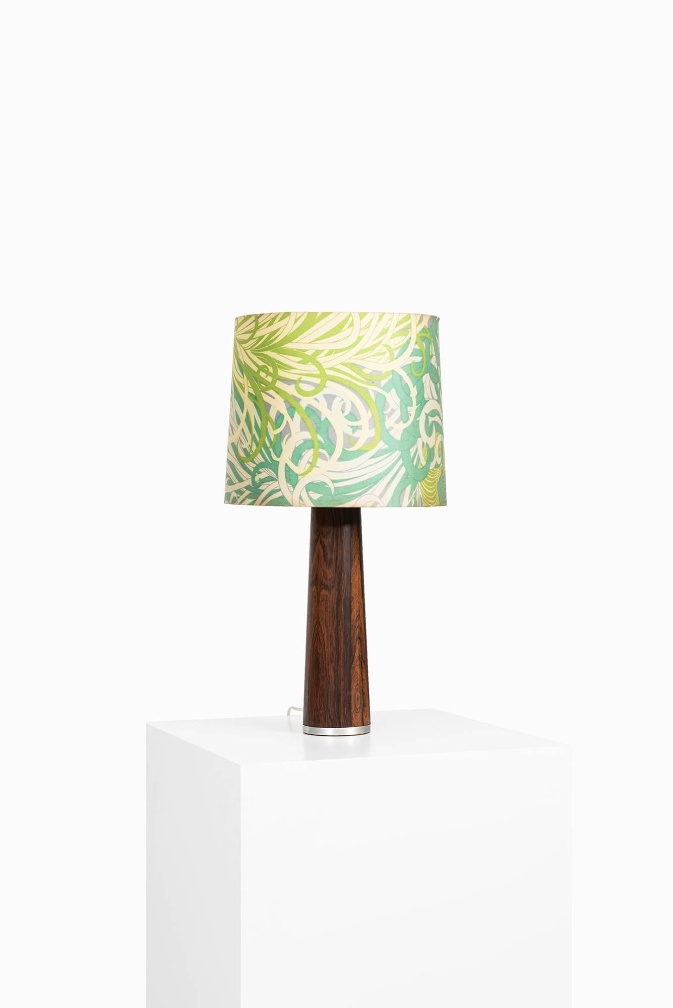 Table lamp in rosewood with floral lampshade. Probably produced in Sweden.
