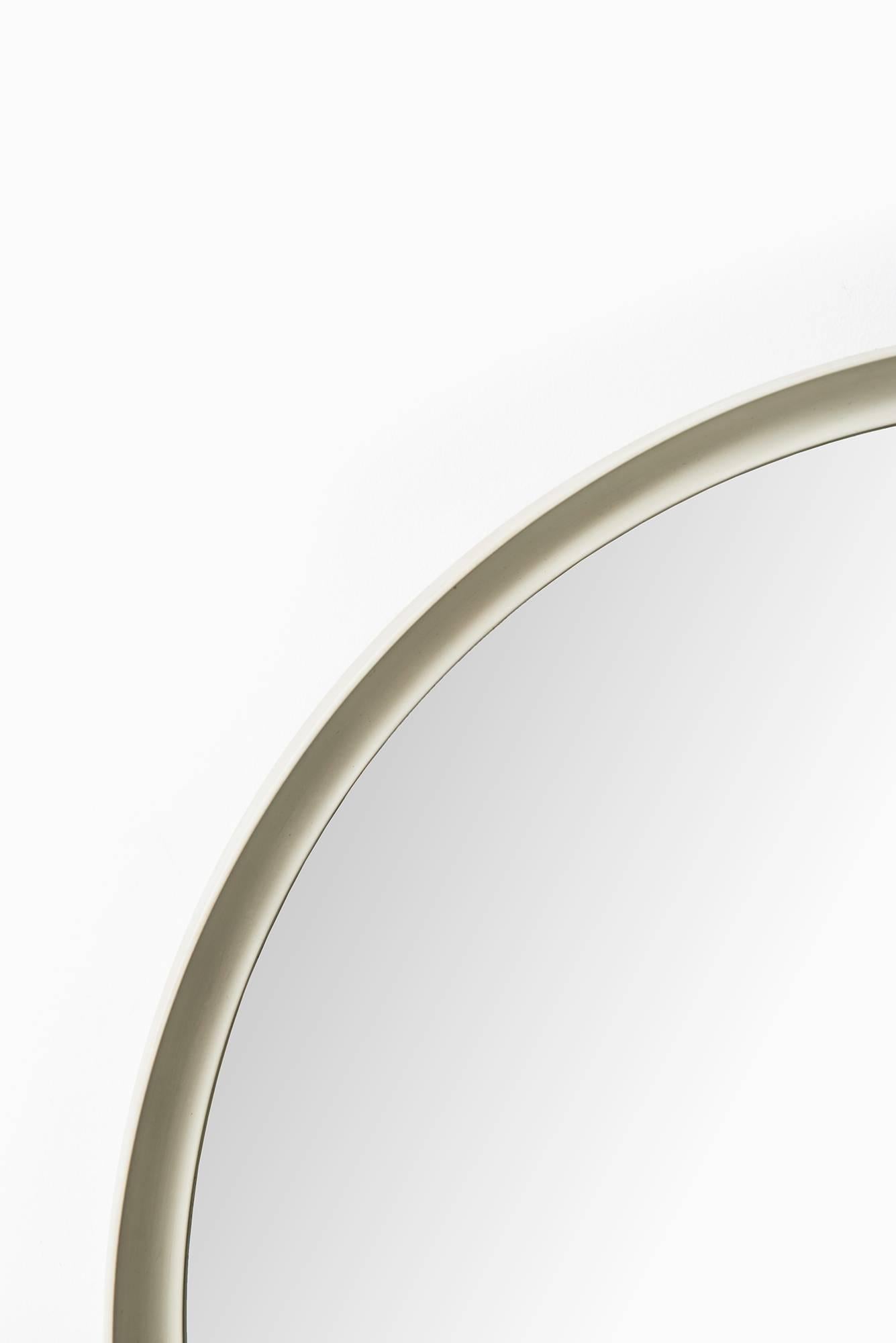 White lacquered round mirror produced in Sweden.