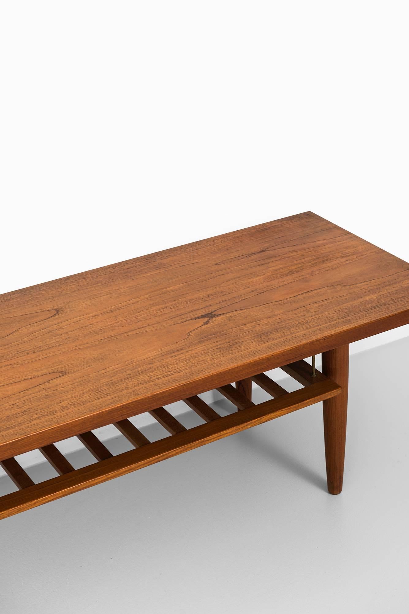 Long side table or coffee table with magazine rack in teak. Produced in Sweden.
