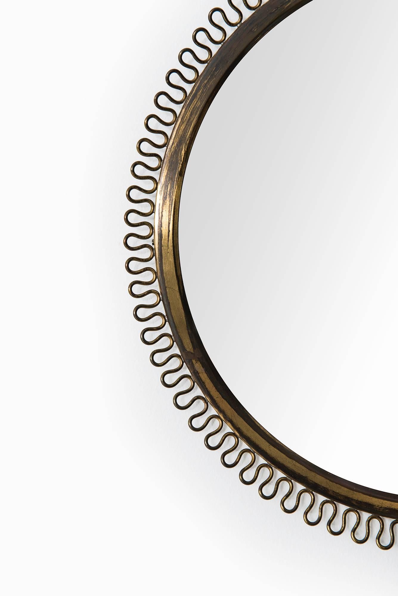 Round mirror in brass designed by Josef Frank. Produced by Svenskt Tenn in Sweden.