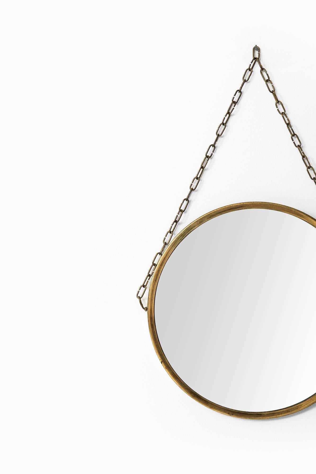 A pair of round mirrors in brass produced in Sweden.