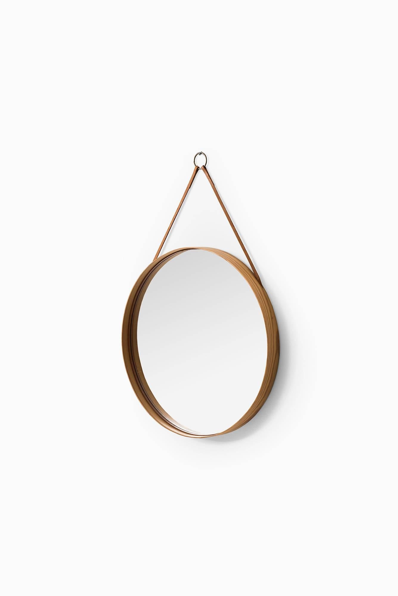 Round mirror in pine and leather model nr 103. Produced by Glasmäster in Markaryd, Sweden.