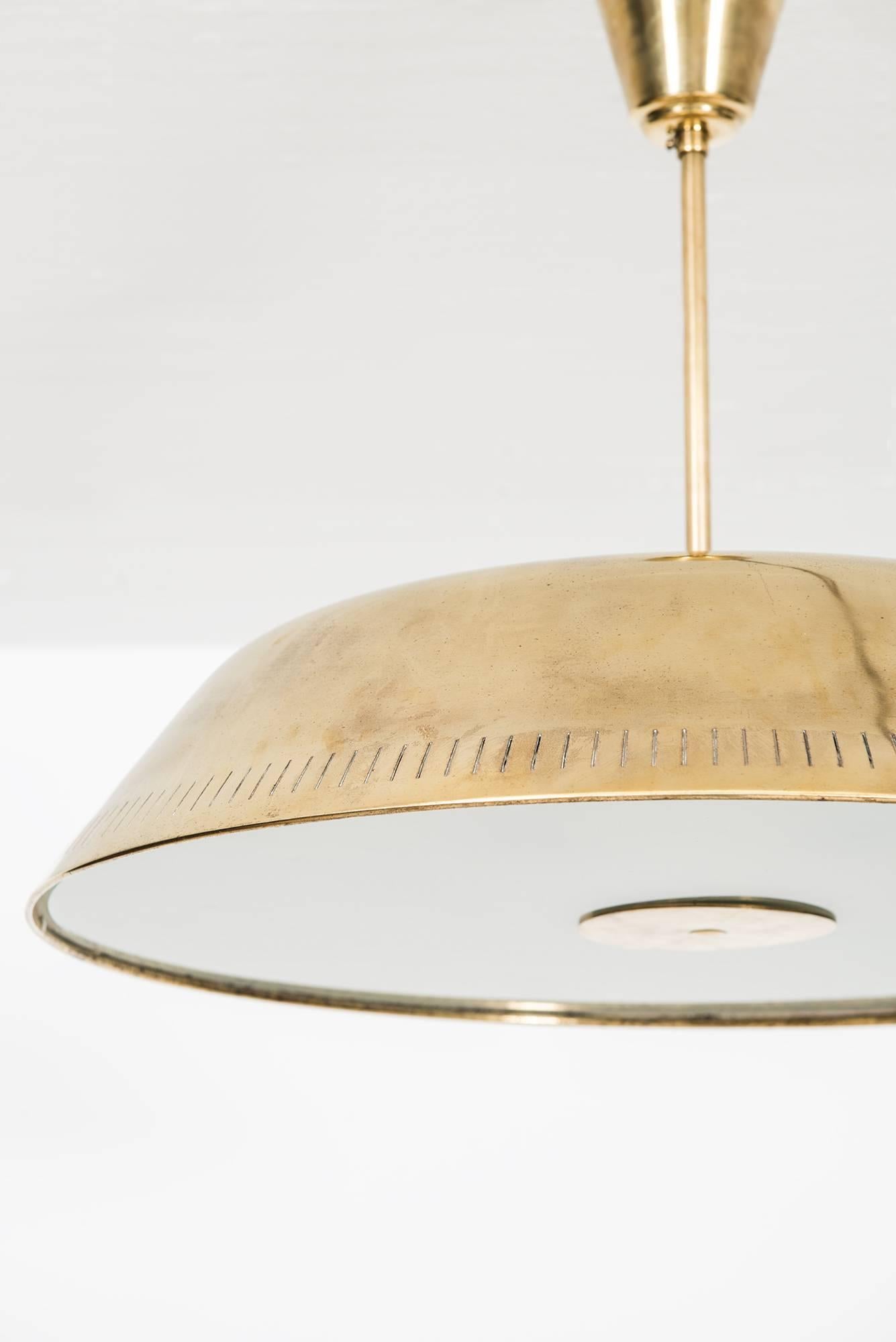 Rare ceiling lamp in brass and glass. Produced by Böhlmarks in Sweden. Six downlights and three uplights.