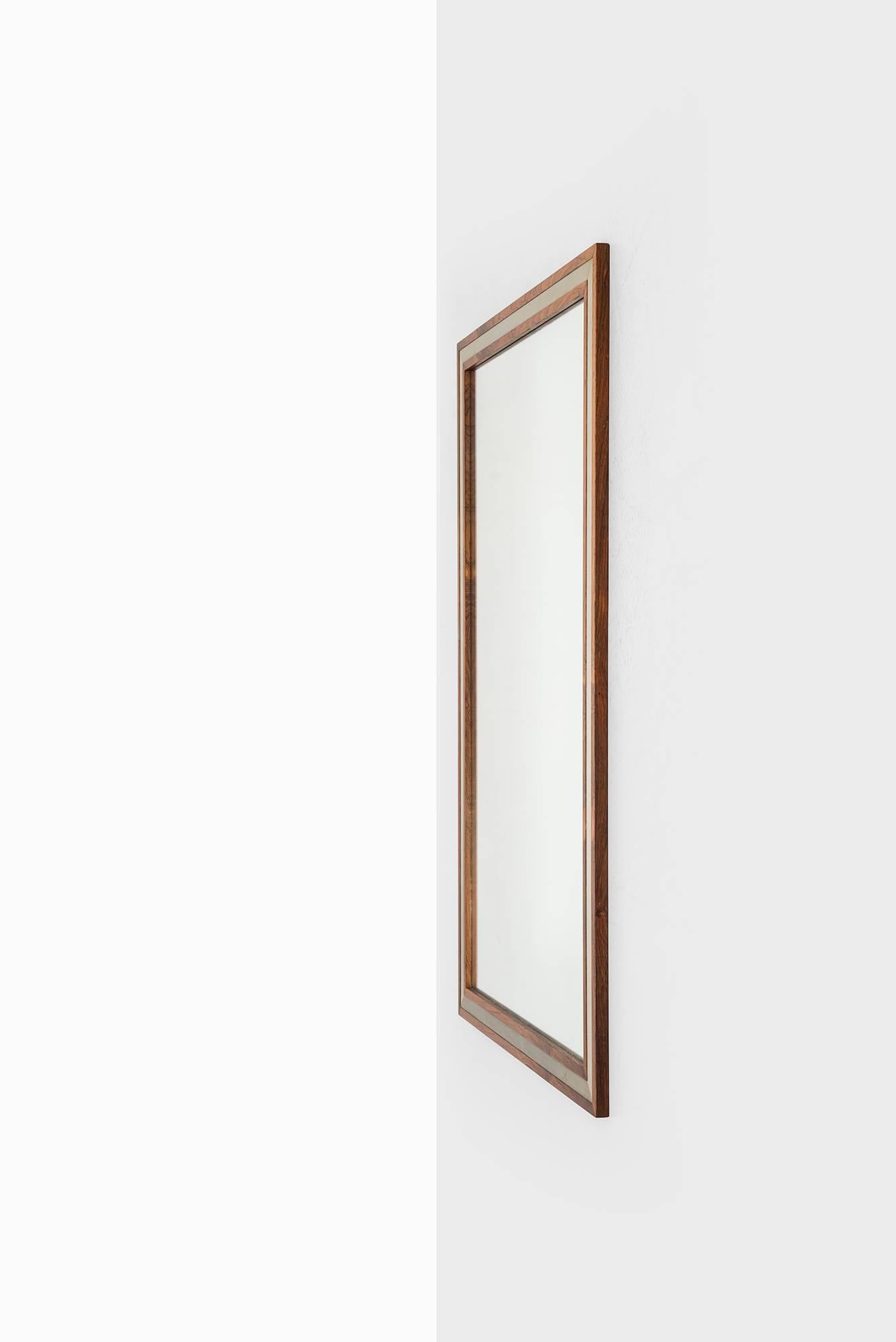 Rare and large mirror in rosewood designed by Aksel Kjersgaard. Produced by Odder in Denmark.