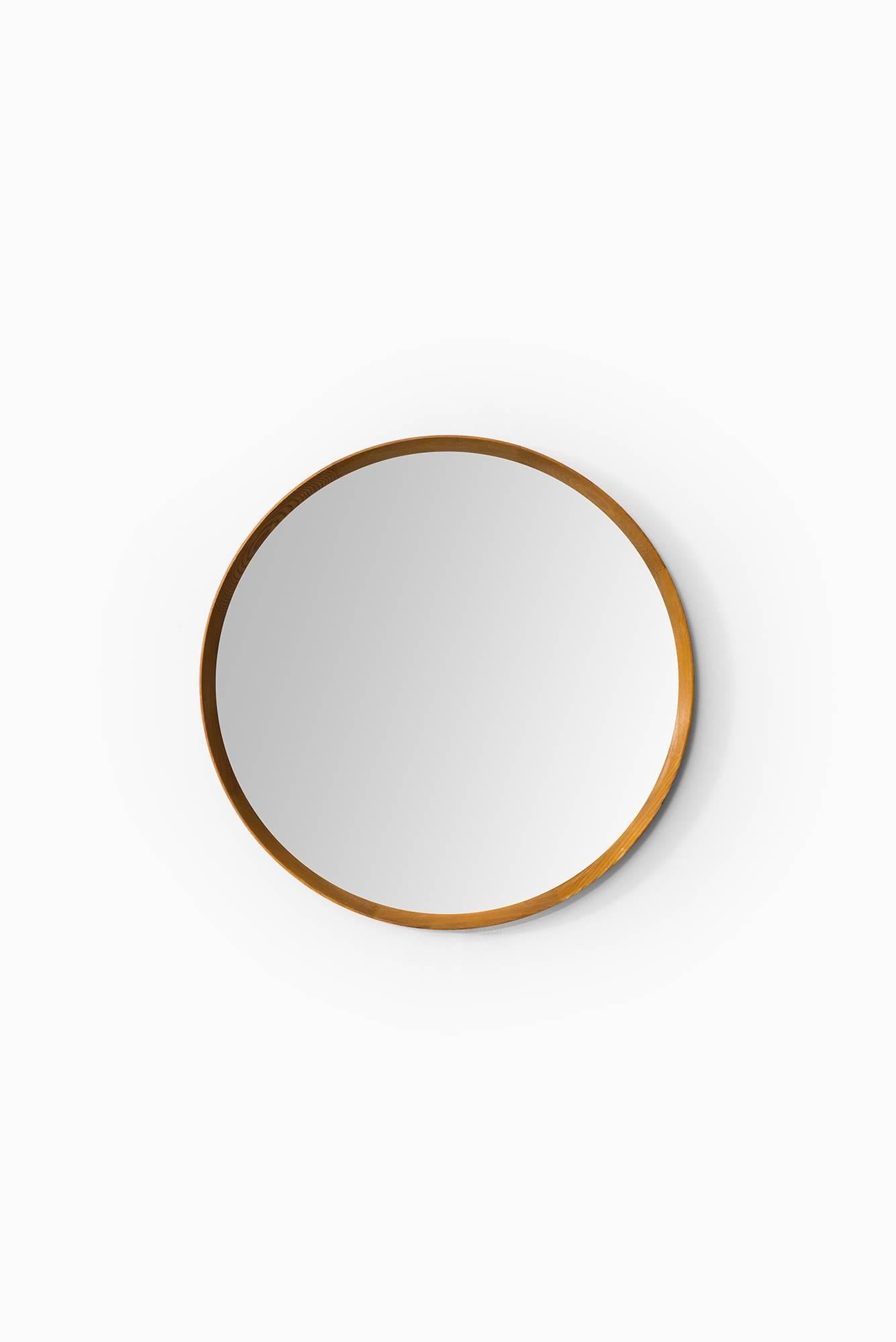 Round mirror in Oregon pine produced in Sweden.