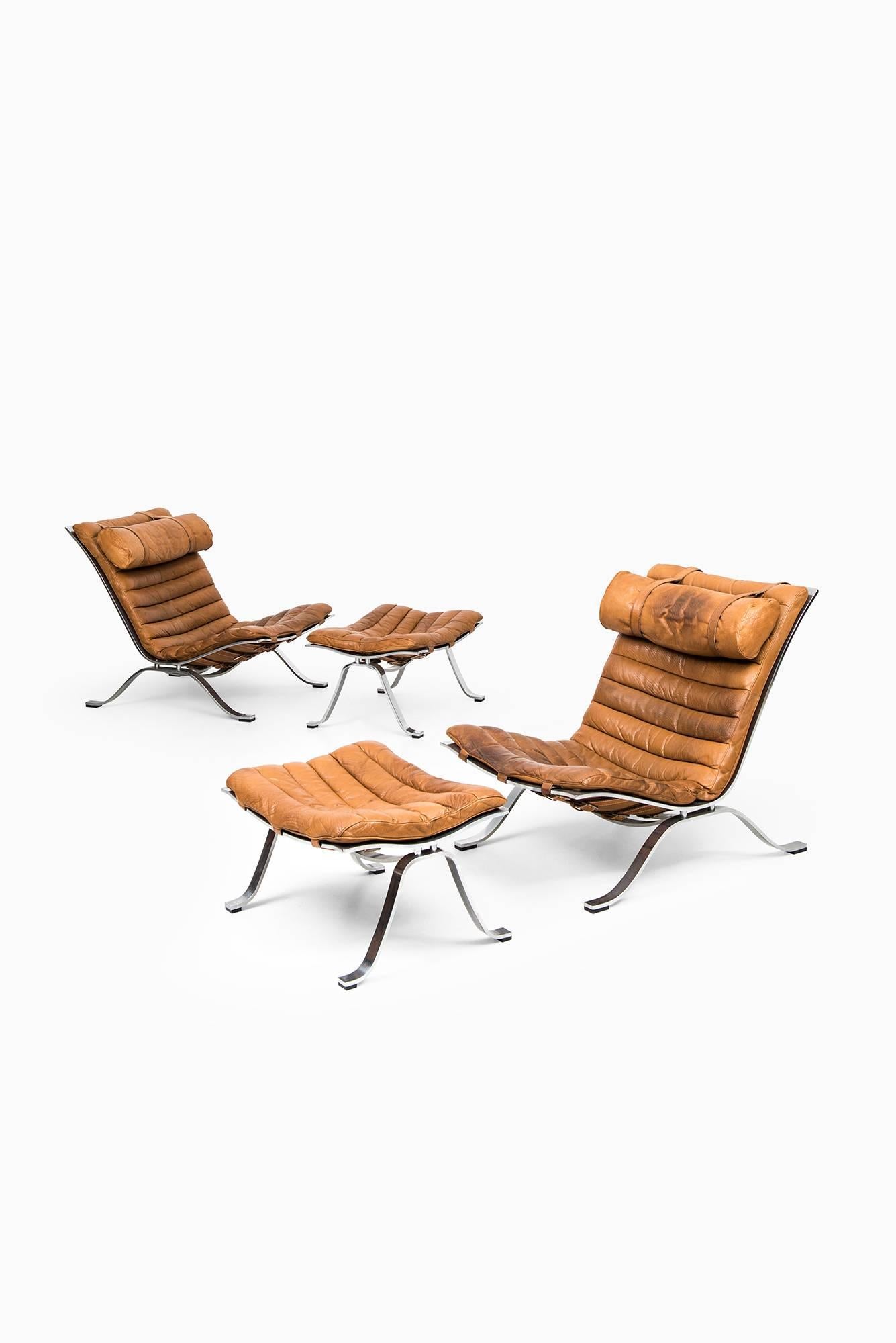 Rare pair of easy chairs with foot stools model Ari designed by Arne Norell. Produced by Arne Norell AB in Aneby, Sweden.