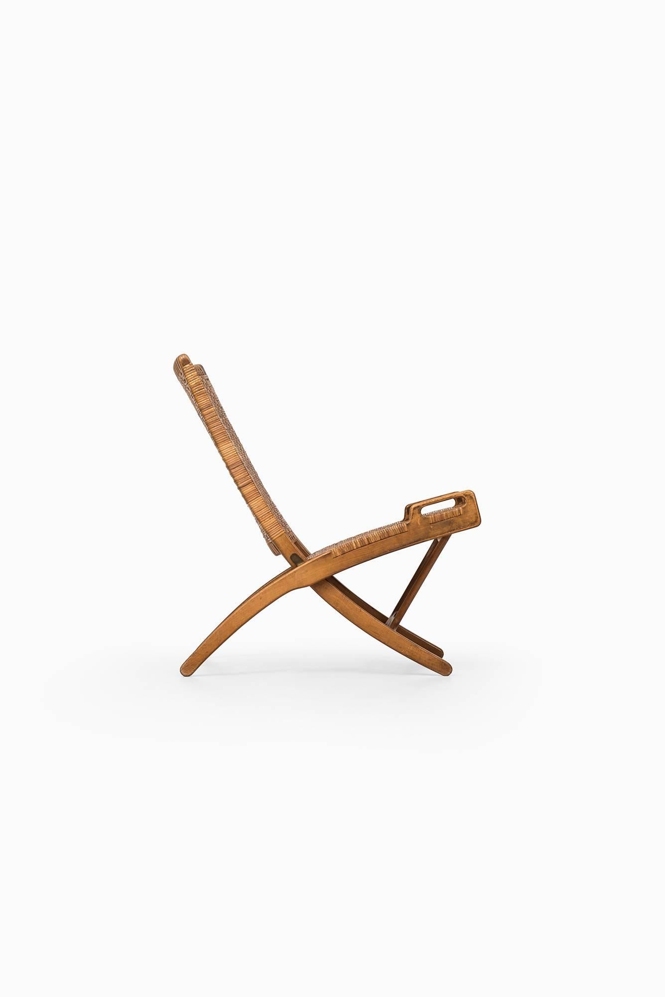Rare and early folding chair model JH512 designed by Hans Wegner. Produced by Johannes Hansen in Denmark. Provenance: Acquired by previous owner’s family at the Cabinetmakers’ Guild Exhibition 1950.