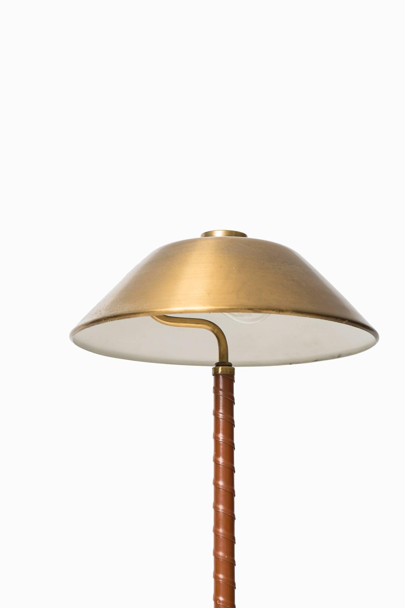 Table lamp in brass and leather. Produced by Einar Bäckström in Sweden.