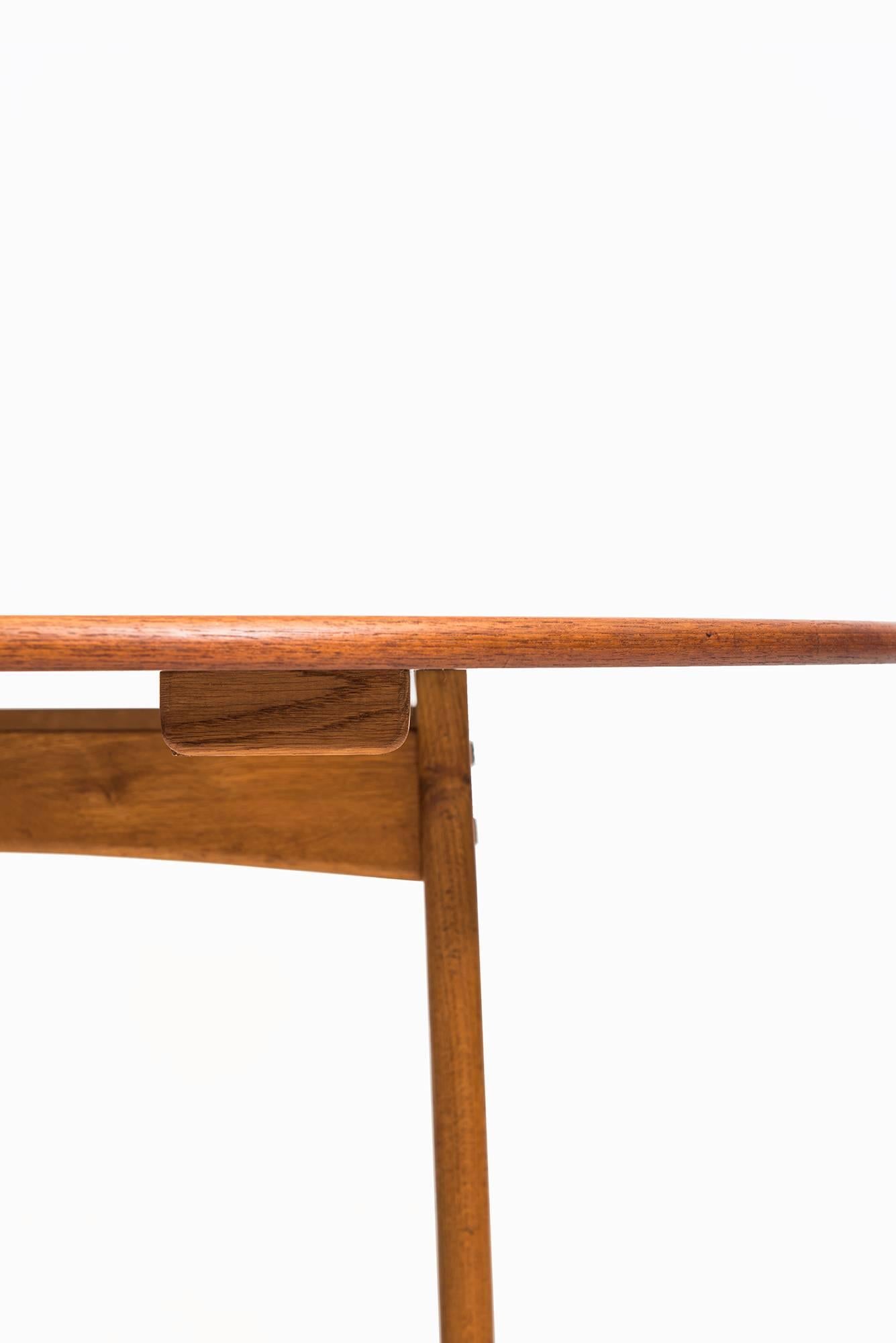 Mid century dining table in teak and oak. Produced in Sweden.