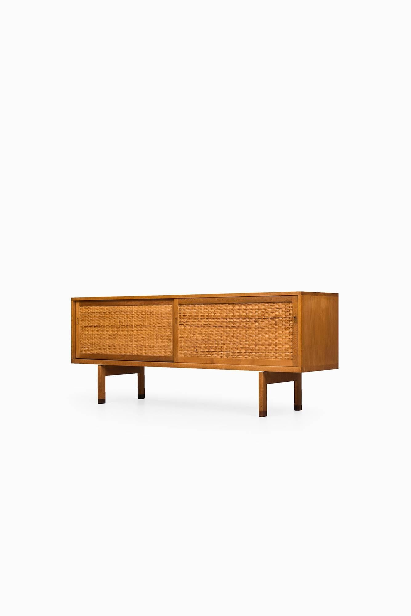 Very rare sideboard in oak with woven cane and rosewood feet designed by Hans Wegner. Produced by Ry møbler in Denmark.
