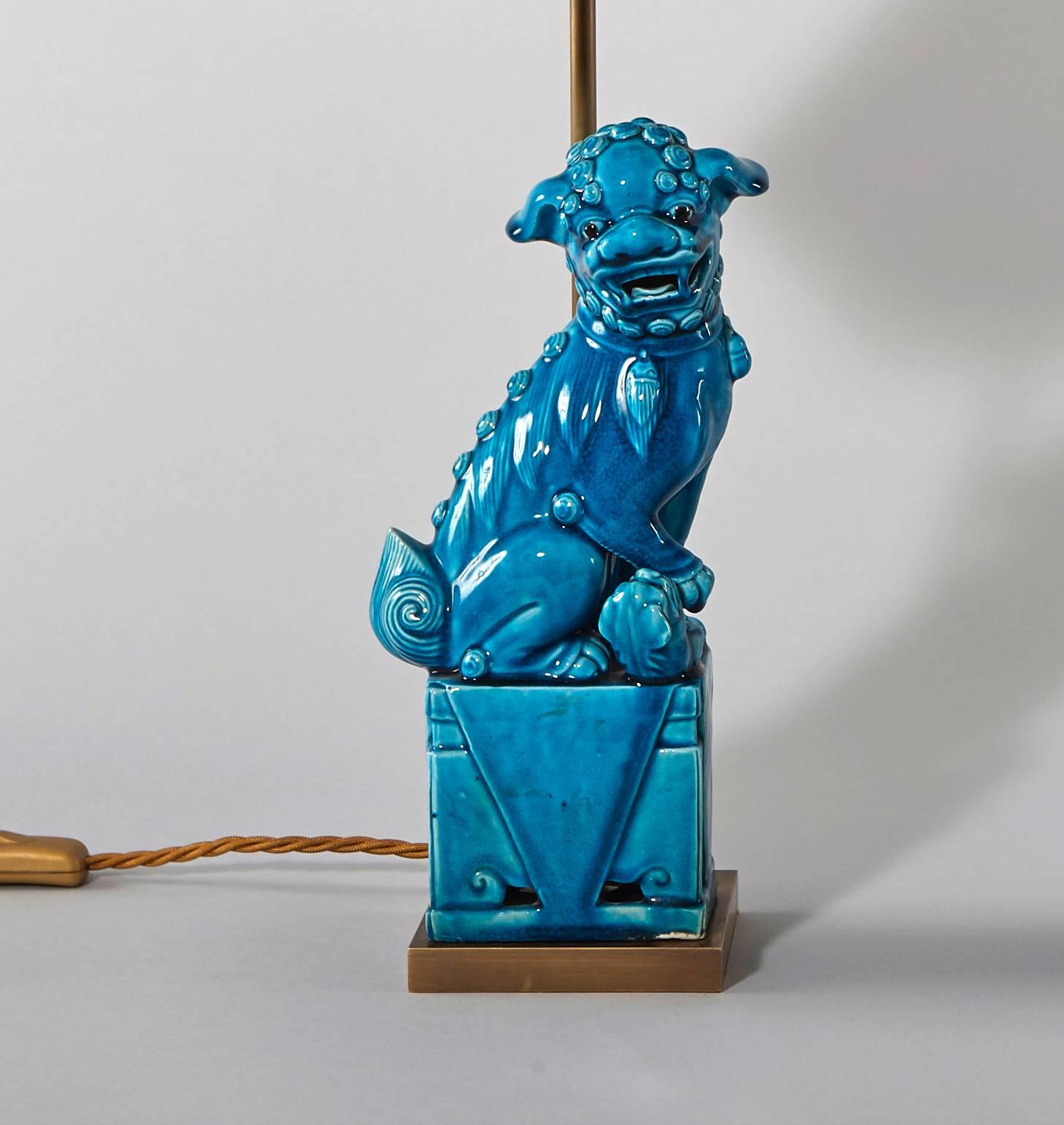 Pair of foo dogs mounted as table lamps. Blue/Turquoise glazed ceramic on a brass base. Hand-painted shade.