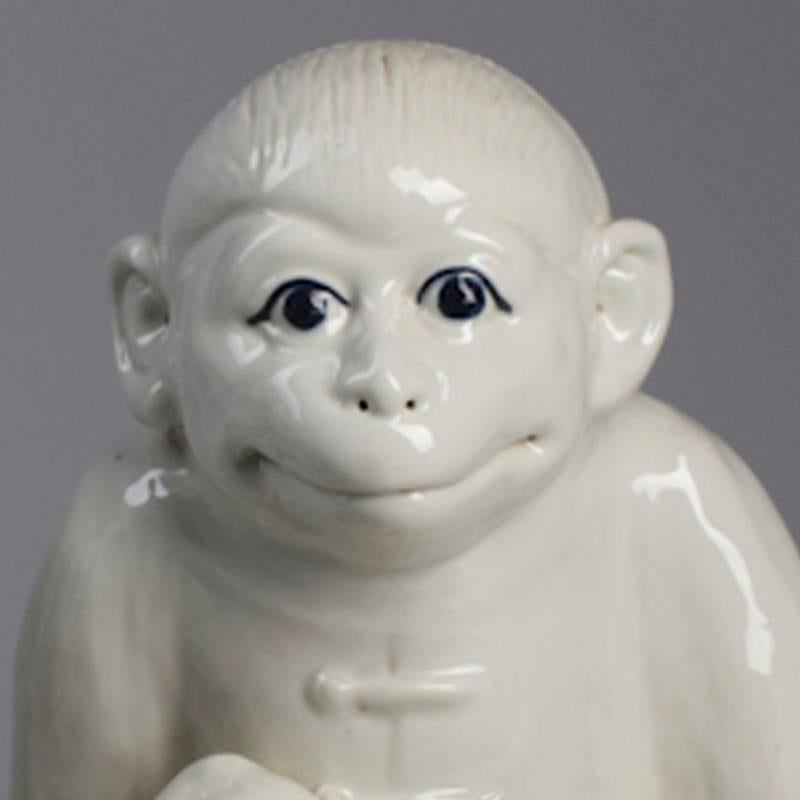 White porcelain monkey in a suit holding a peach. 
China marked on the bottom.