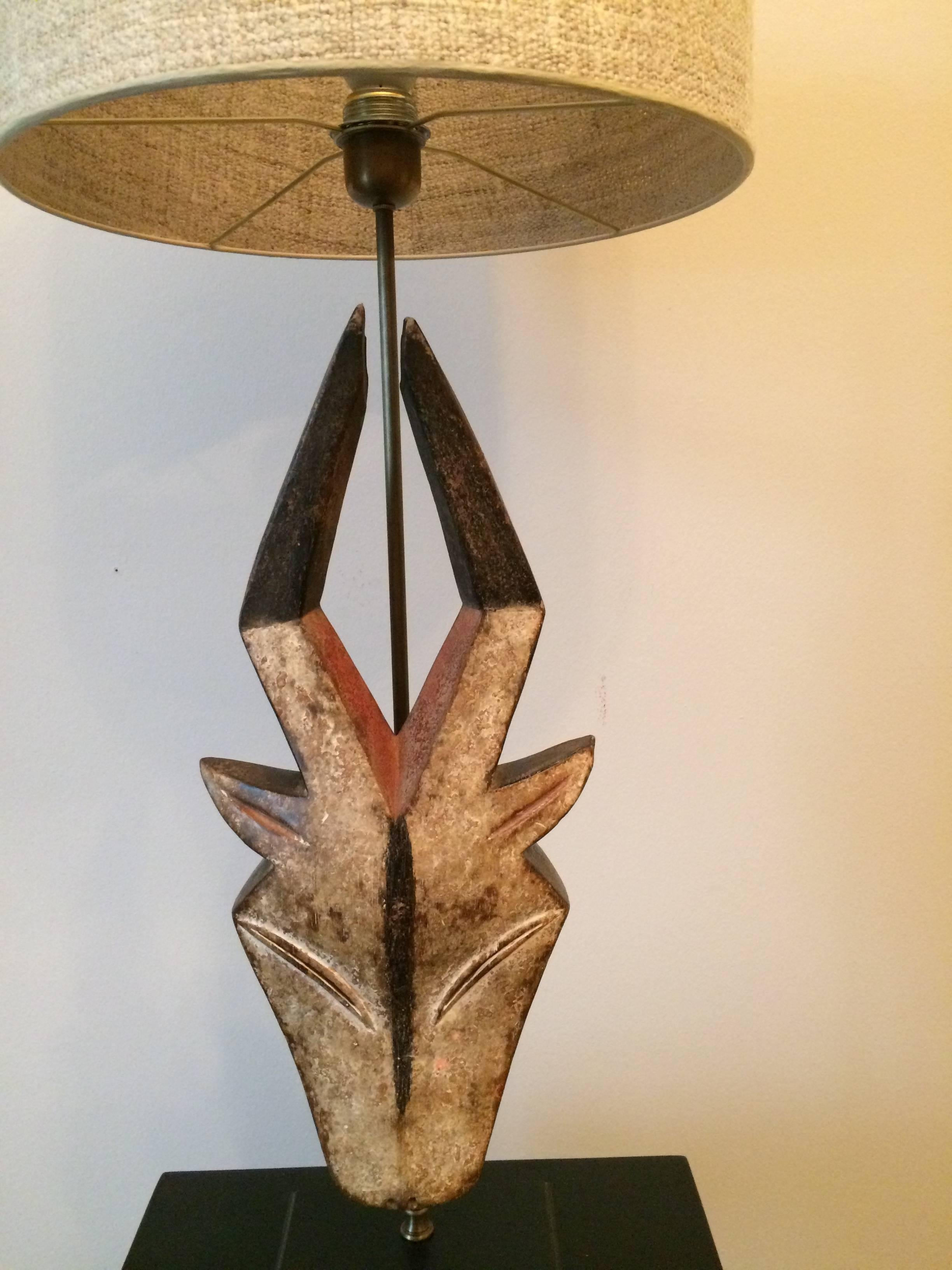 African antilope mask from the tribe Kwele in Gabun.
Mask mounted on a wood base, with tweedy fabric lamp shade
Height of the mask 51 cm.
