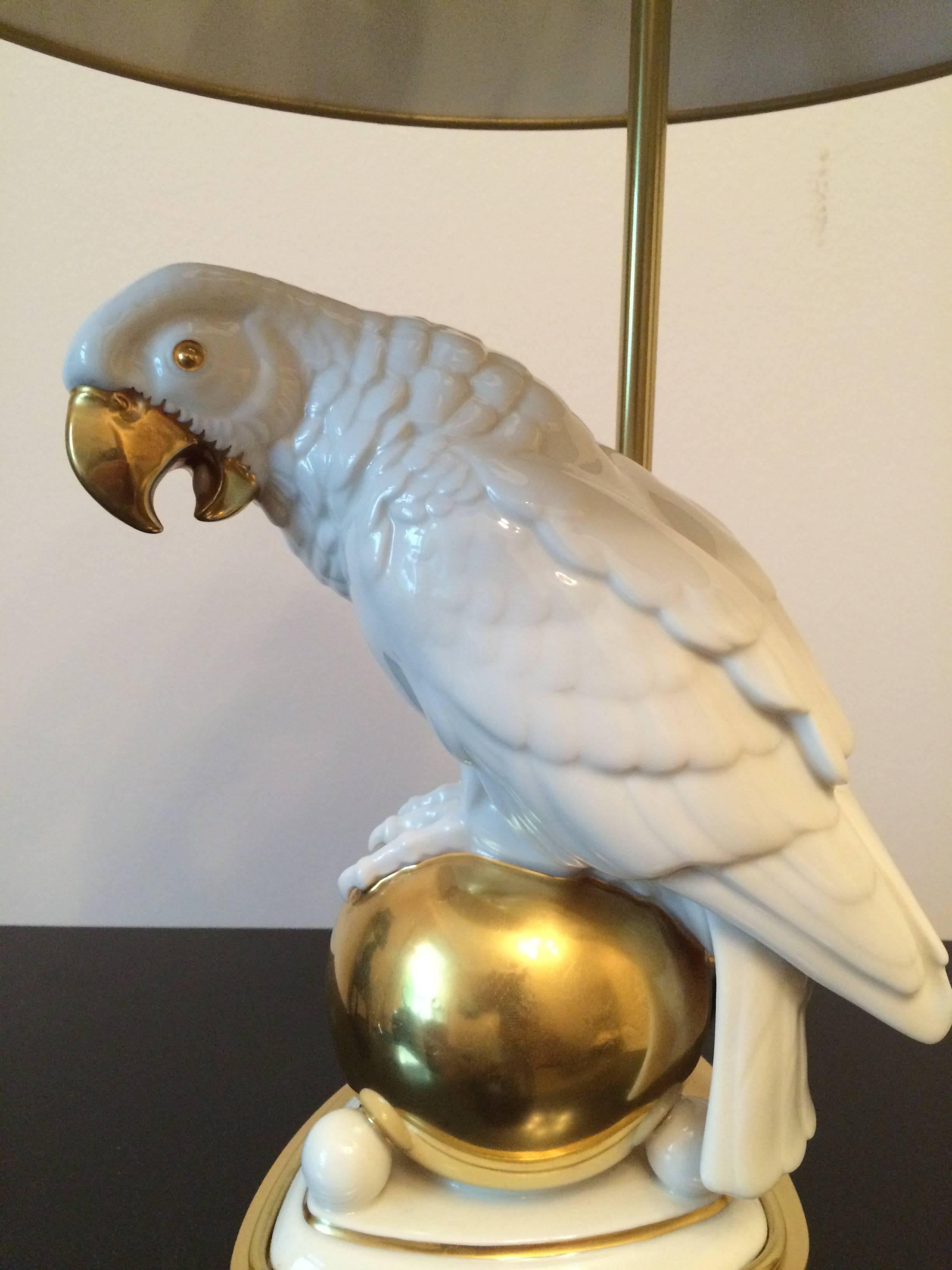 Porcelain parrot on a golden globe mounted as a table lamp on a brass base.
Hutschenreuther porcelain design by Fritz Klee.
 