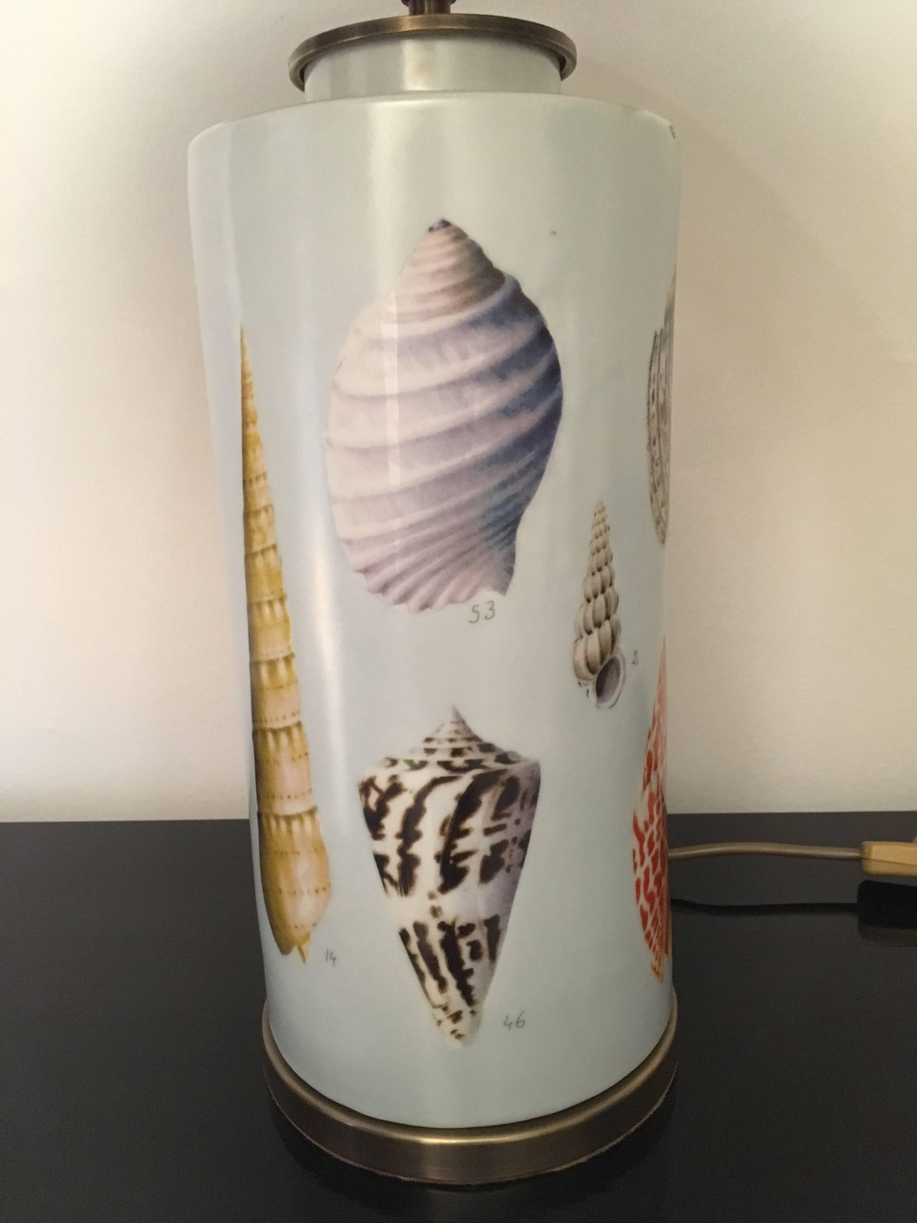Pair of shell design porcelain vases mounted as table lamps in the style of Fornasetti. Hand-painted shades with natural shell as lamp finals.
Diameter of shade is 42 cm.
 
