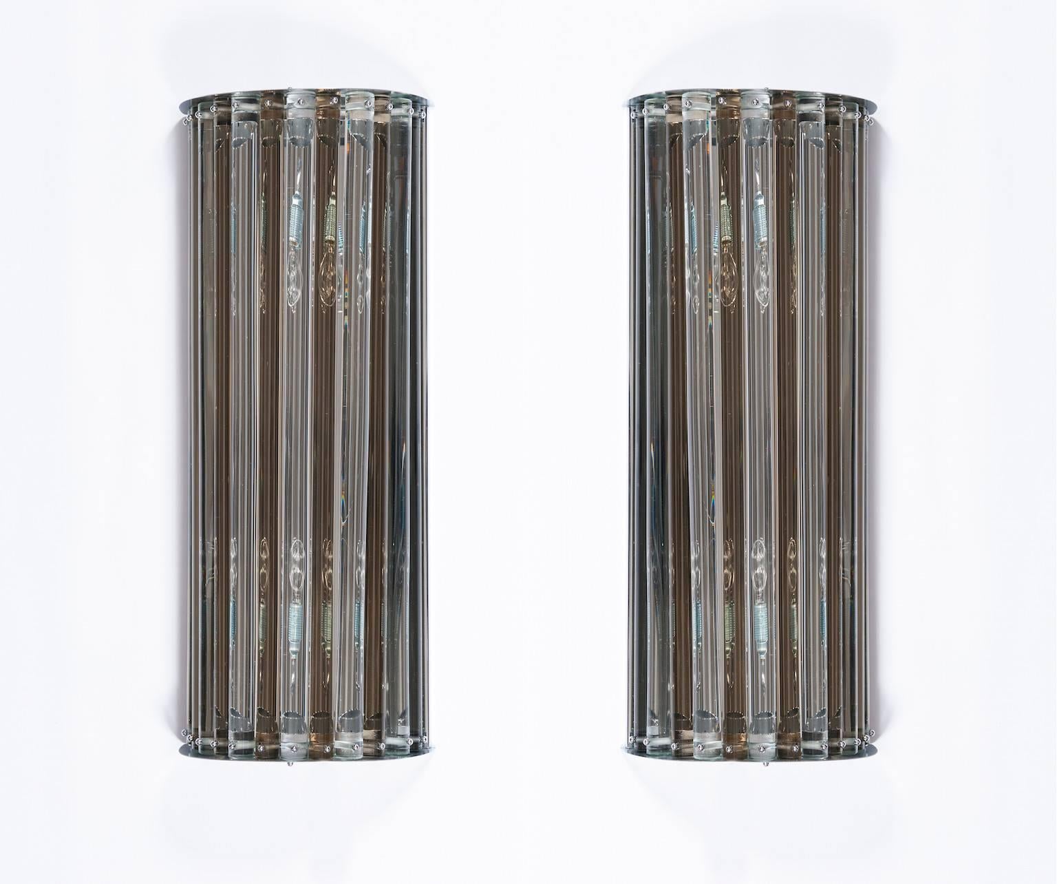 Pair of Italian Murano glass sconces, in very excellent original condition around 1980s, composed by transparents and fumè (Fumè is smoke color) glass cylindrical elements, with an original chrome frame. The sconces are 28.74 inches high, 5.91