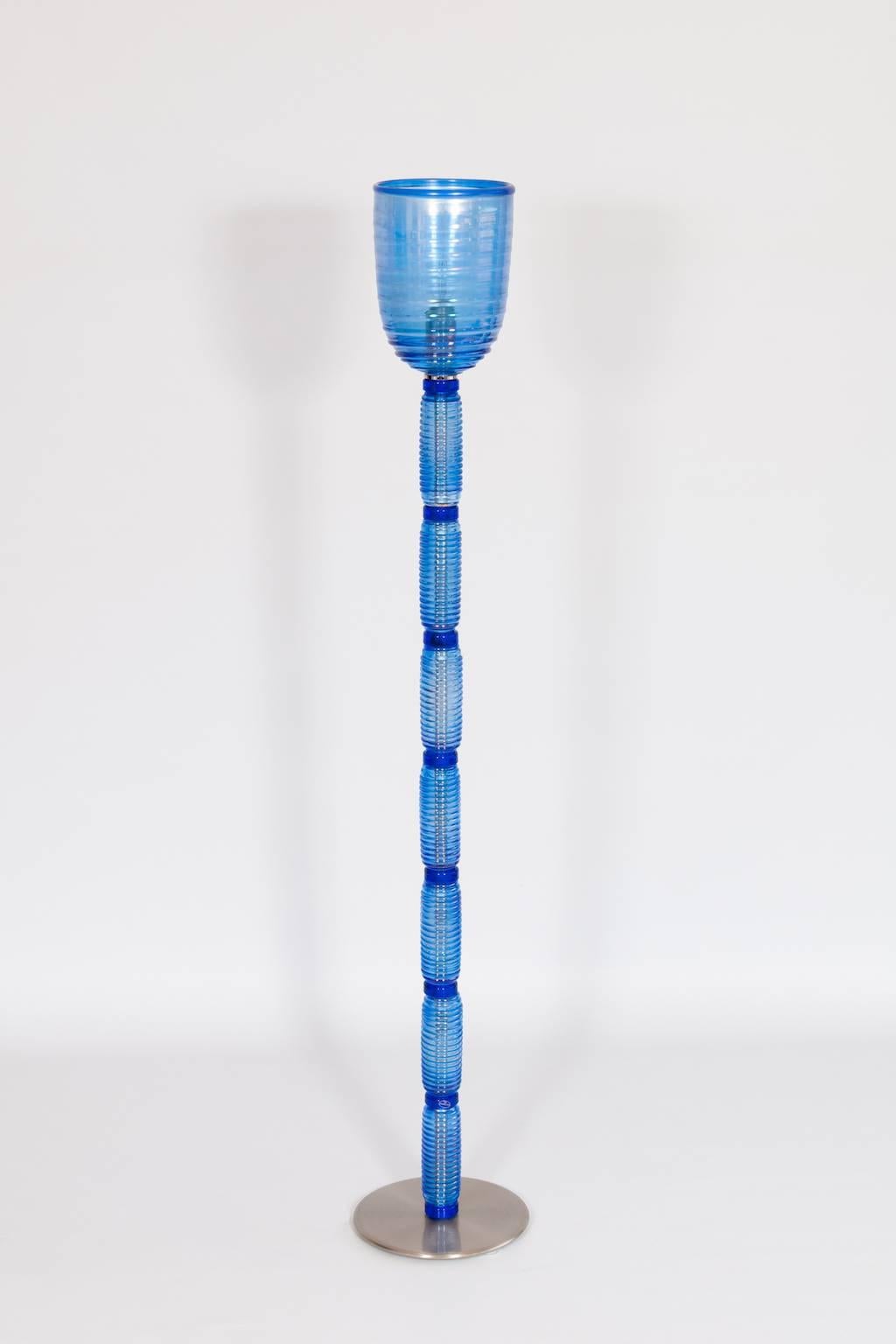 Floor Lamp in Light Blue and Iridescent Color Murano Glass Italy 1990s.
This is an exquisite modern floor lamp entirely handcrafted in the Venetian island of Murano in the 1990s. It is composed by a chromed round base, by a light-blue stem made of