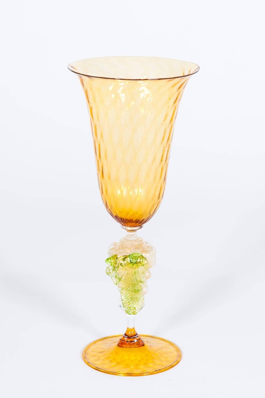 Italian Venetian Goblet in Murano Glass Orange and Gold with a Grape 
Refined Italian Venetian handcrafted goblet in blown Murano glass composed by a small bowl in light-orange and with in the stem a fantastic gold grape with green leaves, both