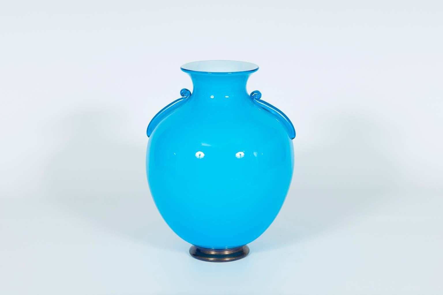 Elegant Italian venetian vase in Murano glass, in very excellent original condition, composed by a base in blue and gold, by a bowl in light blue with two curbs at the sides. The vase in the internal part is in white color.