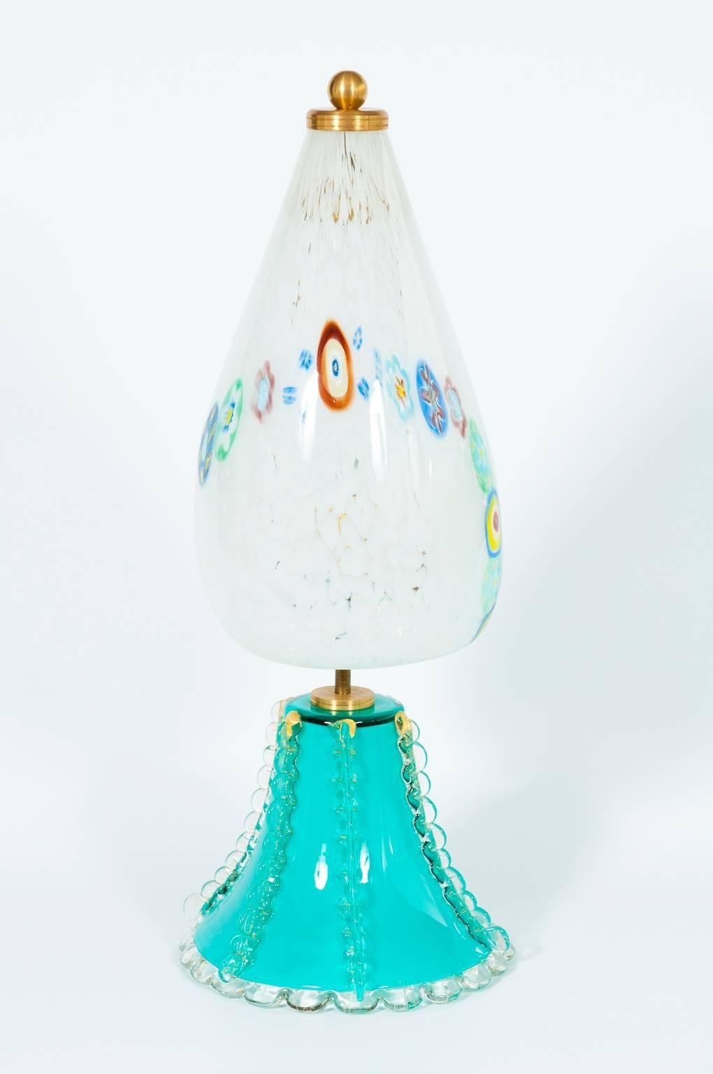 Italian Venetian table lamp in Murano glass, composed by a base in light green with transparent curbs with gold refiniture, and by a glass lamp shade with white spots and with a Murrine line. In very excellent condition, and made in 1980s. The table
