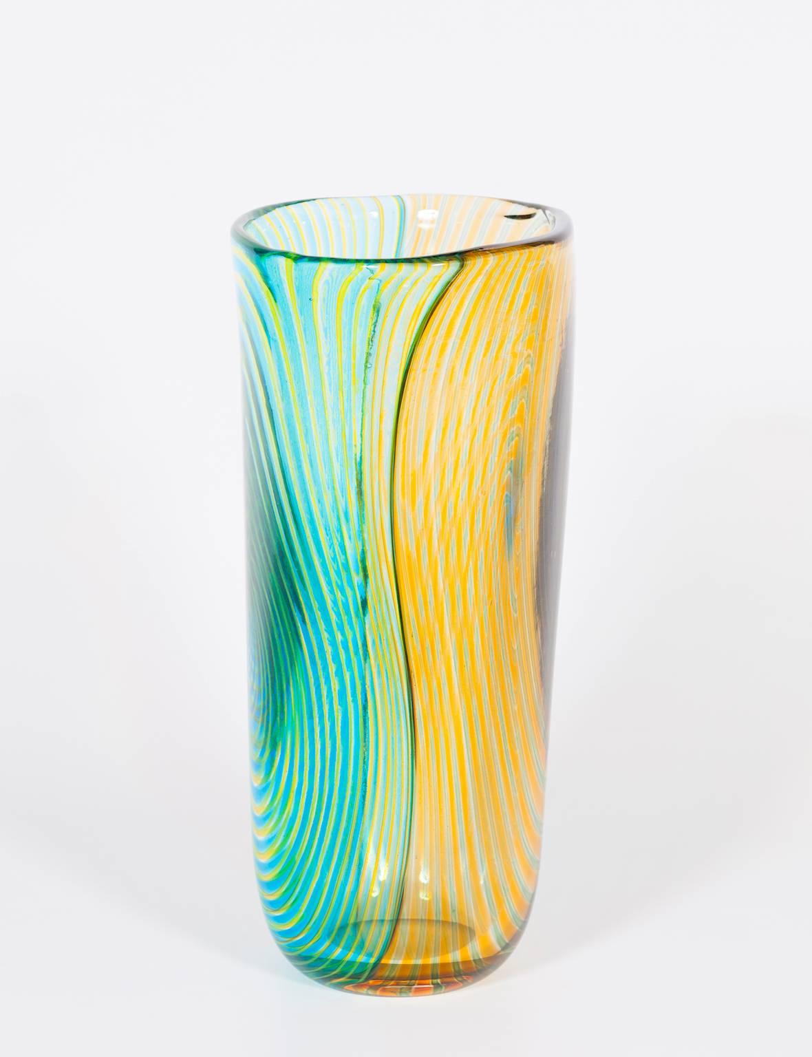 Gestreifte Vase aus mundgeblasenem Murano-Glas Grün-Orange und Hellblau, 1990er Jahre Italien.
Dies ist eine einzigartige gestreifte Vase, mit doppelt gefärbten Seiten und Streifen im Inneren der geblasenen Technik. Die Hälfte der Seite ist