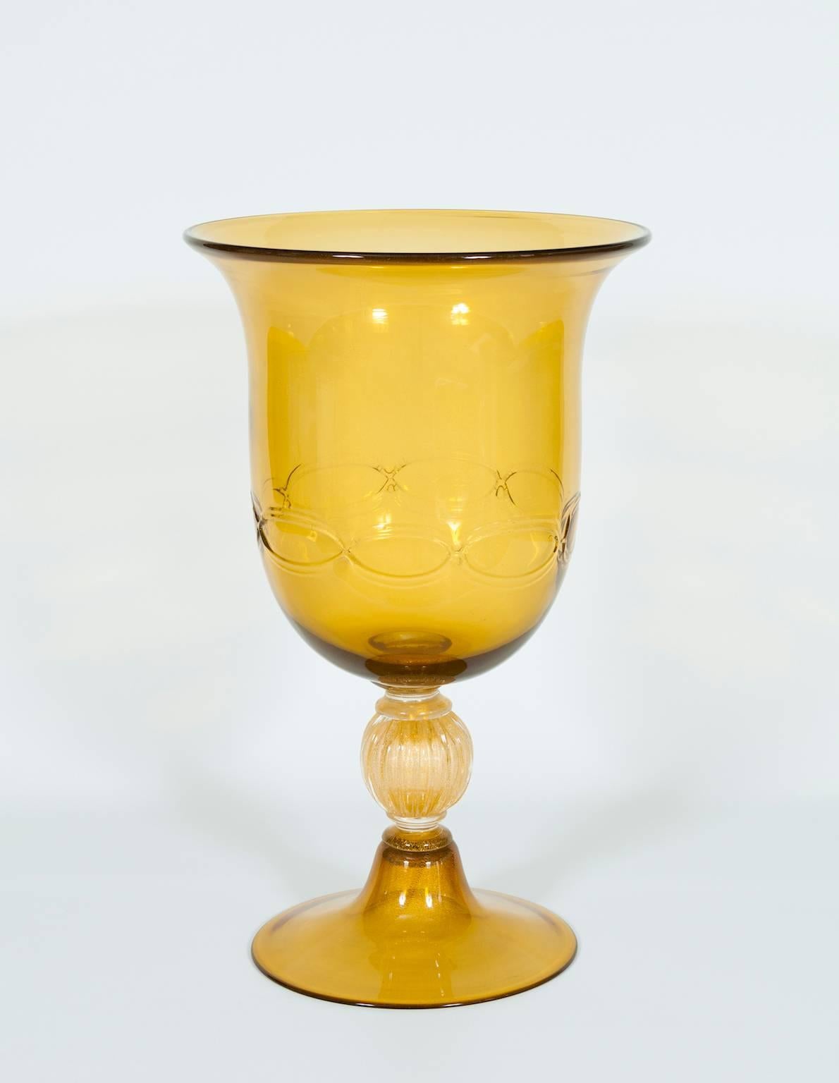 Italian cup in Venetian Murano glass amber and gold, composed from a base in amber and with on a gold striped sphere, with above an amber cup with a gold tape around the low part. The cup is in very excellent original condition, made circa 1980s.