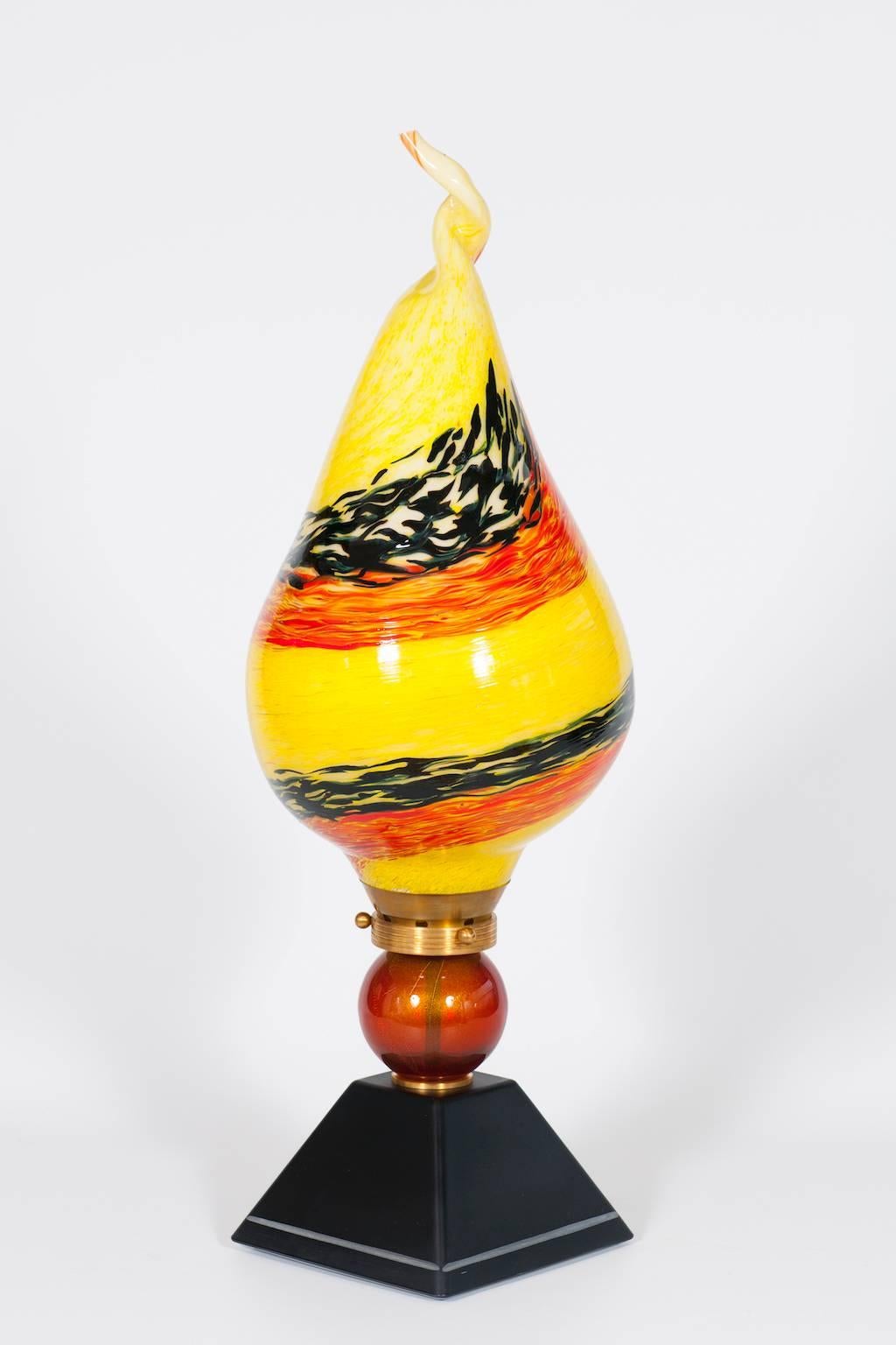 Very Unique, and Elegant, Italian Venetian, Flame Table Lamp, blown Murano Glass, yellow orange black in pasta, composed by a black basement  with a white line finishes, followed by a red and gold sphere, and culminating with a huge flame in blown