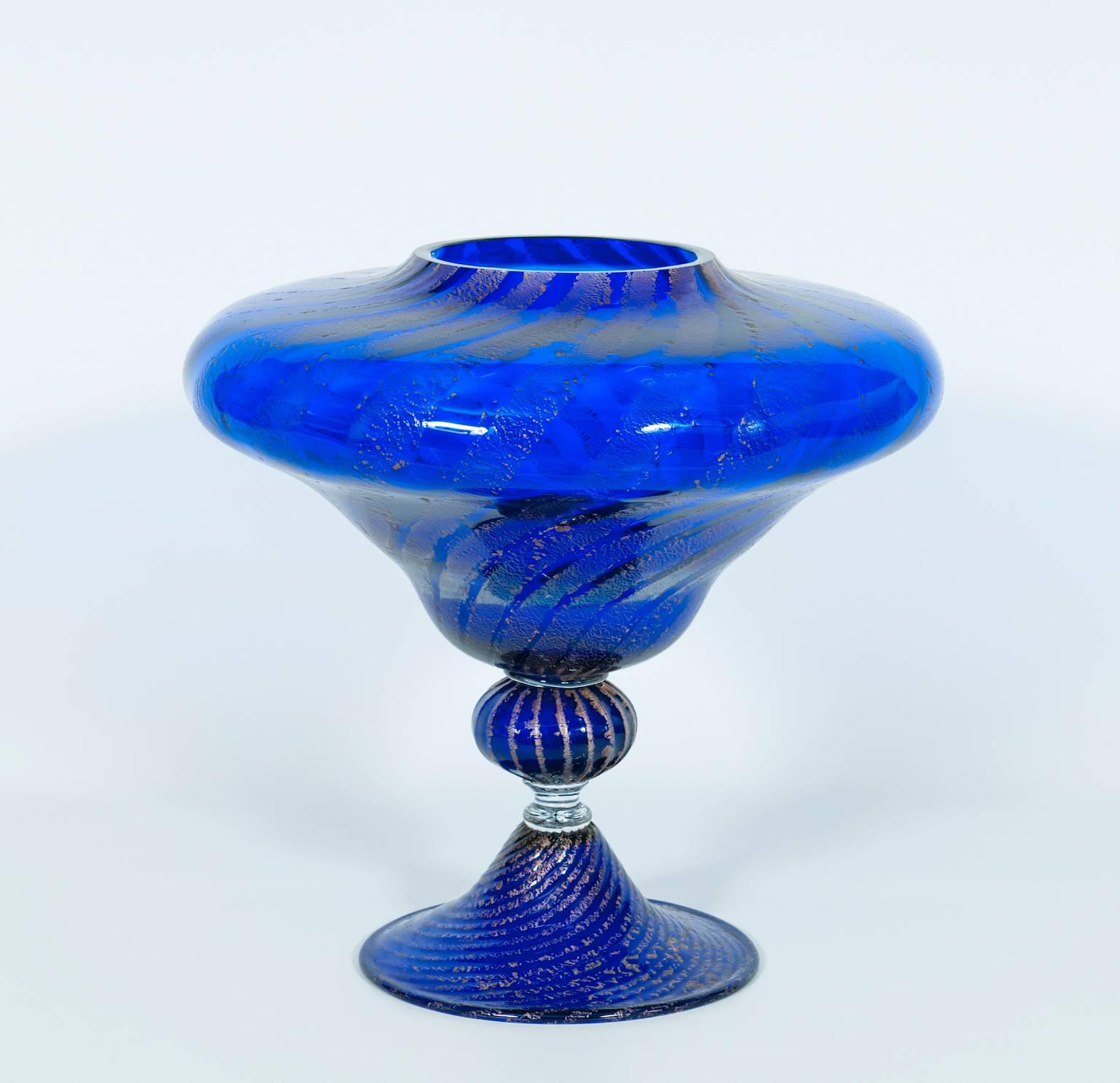 Italian Vase in blown Murano Glass Blue and Silver finishes  1980s.
Italian vase in Murano glass blue and silver, composed by a twisted striped base, in the middle from a striped sphere with above a large twisted striped bowl. This is a masterpiece