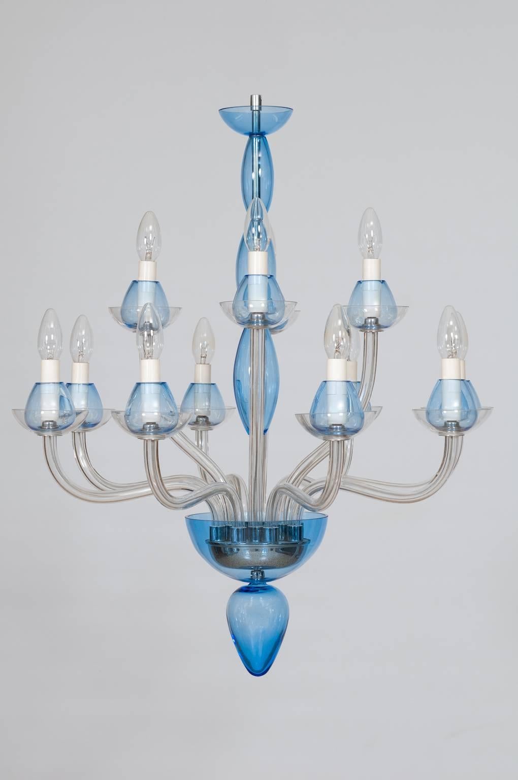 Elegant, and Modern Italian Venetian,Chandelier, blown Murano Glass, Transparent & Light-Blue, 1990s, composed by transparent twelve arms having each one a cup colored transparent and light-blue, and the main stem having the finishes in light-blue,