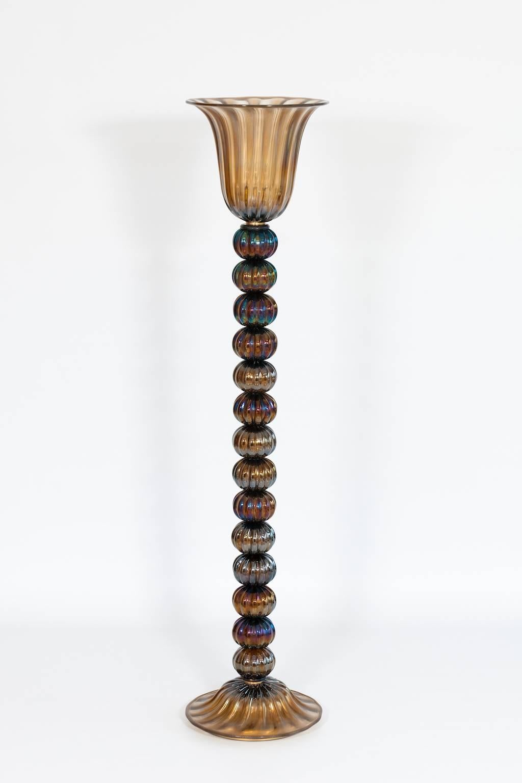 Elegant lampadaire italien en verre de Murano Lampadaire italien en verre de Murano pagliesco avec irisation des années 1980,  composé d'une base et d'un bol avec à l'intérieur une lumière et ayant au centre une tige avec des sphères, le tout est