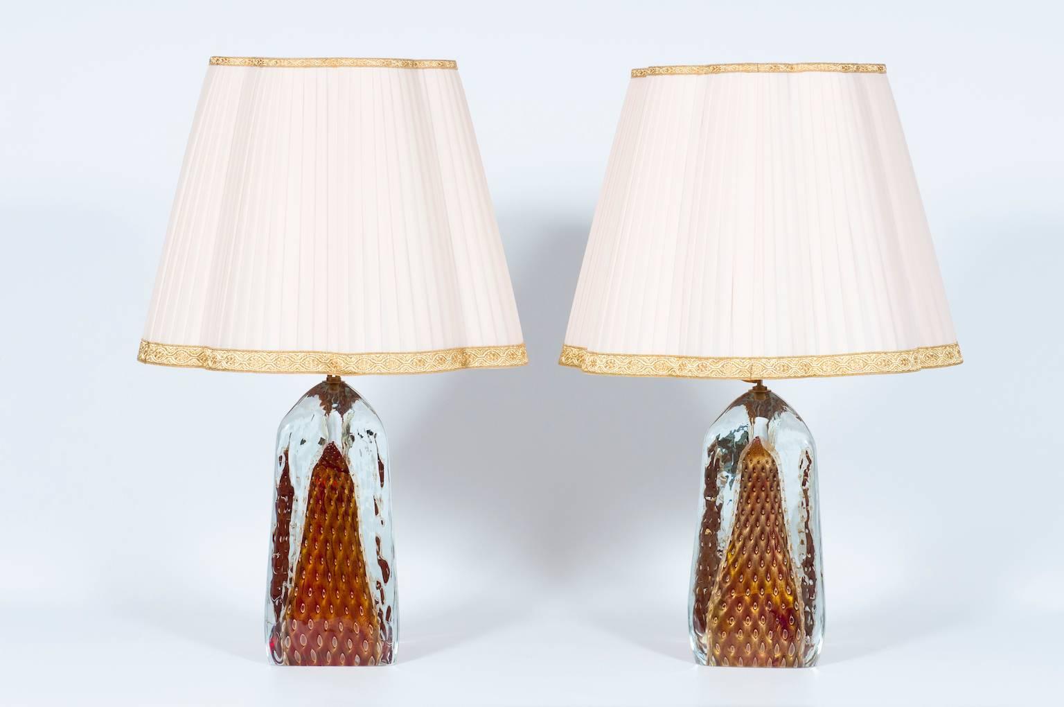 Elegant pair of Italian table lamps in Murano glass red with 24-karat gold bubbles all submerged in transparent glass, in a very particular triangular shape, with an elegant brass frame. All parts were made and realized in the Murano Island, circa