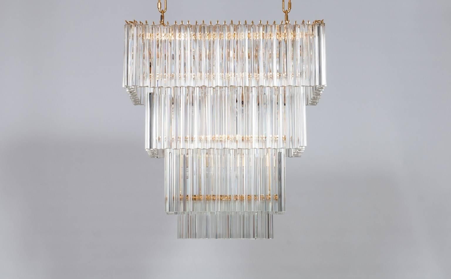 Amazing Italian rectangular Chandelier in Murano glass transparent and in colored gold frame, in limited edition 2017. The chandelier is a limited edition made to order, composed by transparent Triedro elements disposed on four separate levels, all