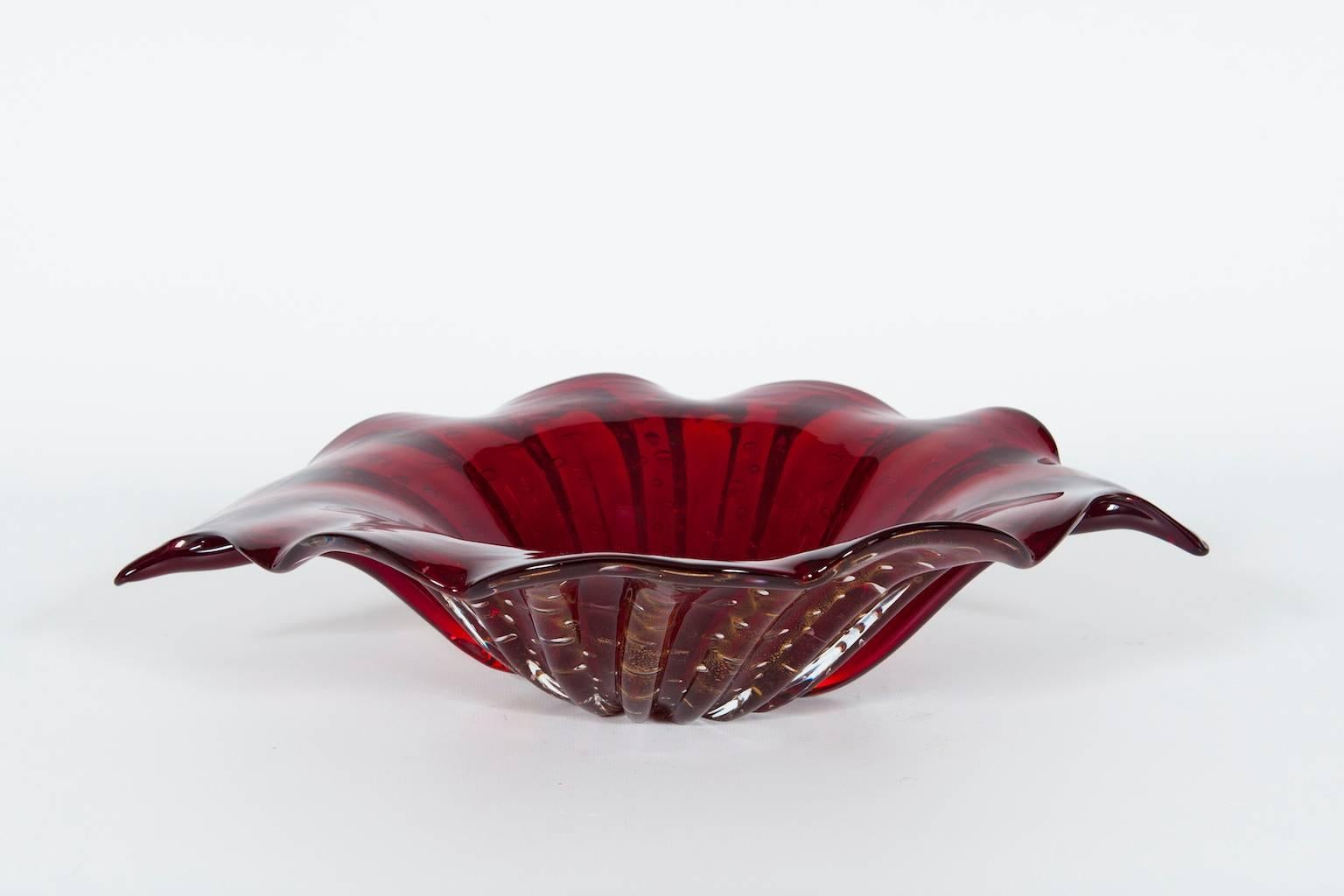 Elegant Italian centrepiece in Murano glass red with 24-karat gold bubbles, in a very particular shape. The item were made and realized in the Murano Island, circa 1980s by blowing and handmade. The centerpiece is in very perfect original