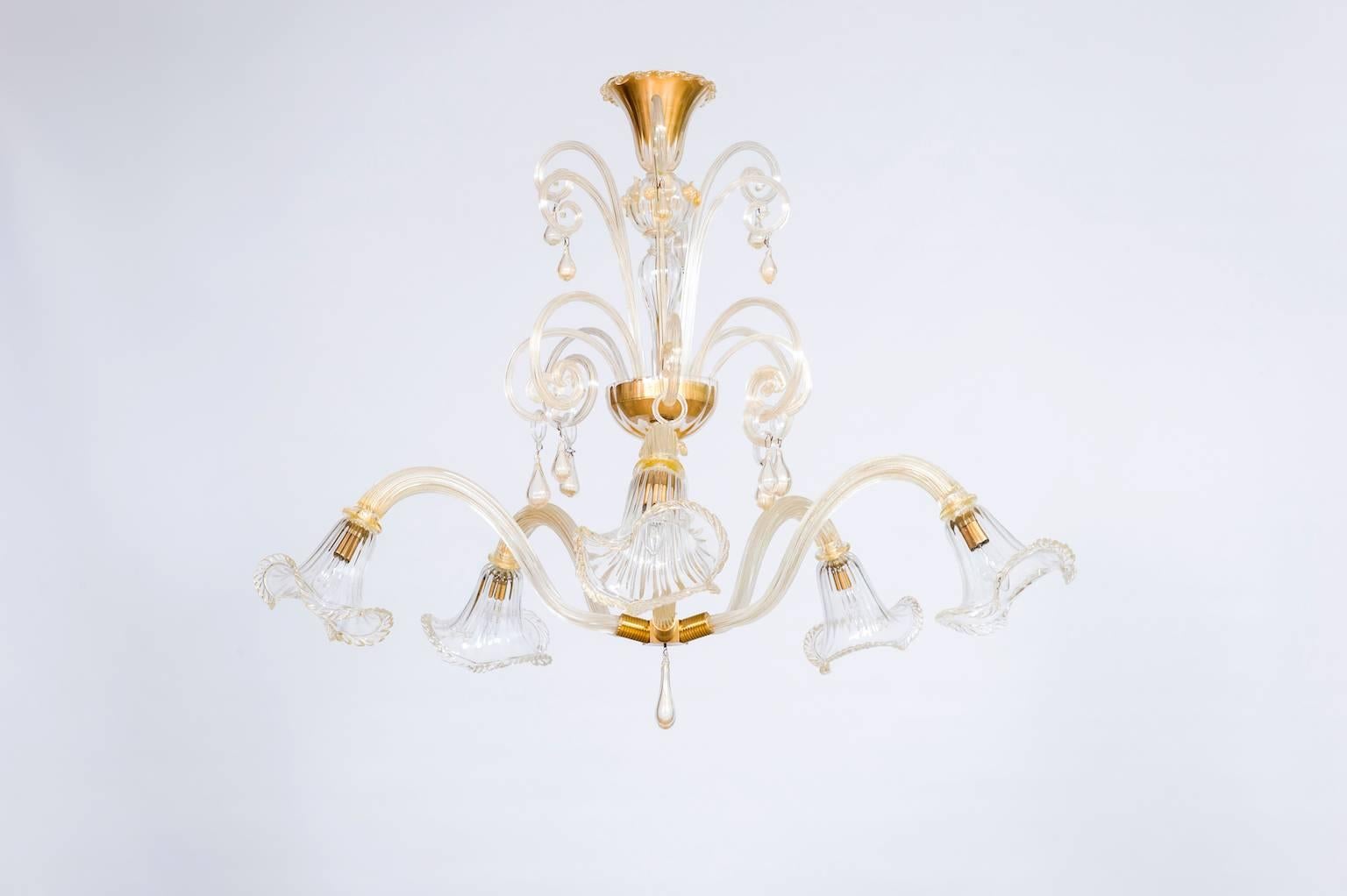 Italian Chandelier in Gold and Blown Murano Glass, Big Bells and Pendants 1970s.
Elegant and unique limited edition Chandelier in blown Murano glass with 24K Gold, made of two levels. The upper level is made of golden Murano glass decorations. The