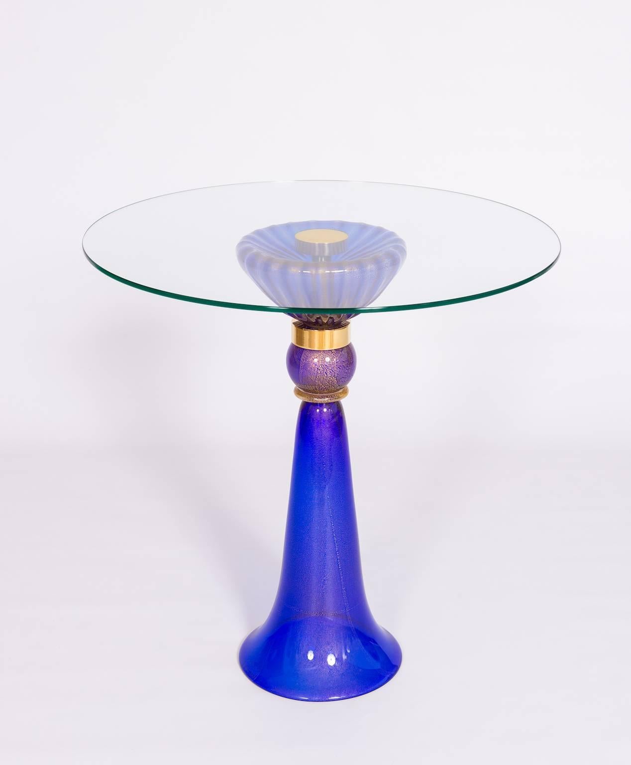 Außergewöhnlicher italienisch-venezianischer Cocktailtisch, mundgeblasenes Muranoglas, Blau & 24-Karat Gold, 1990er Jahre;
Sie besteht aus einem blauen, robusten Sockel mit einer Glaskugel darüber und einer großen Schale, oben eine runde,