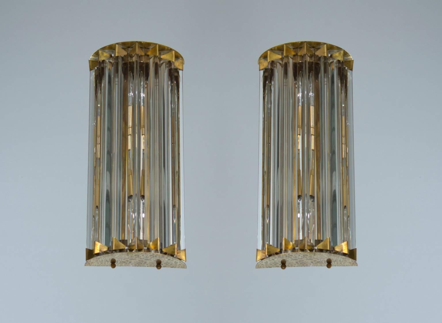 Pair of Italian sconces in Murano glass attributed to Camer Glass 1960s, Italy.
This gorgeous pair of Italian Murano sconces is attributed to Camer Glass. The sconces are composed of clear glass Triedro elements, forming two semicylinders, and