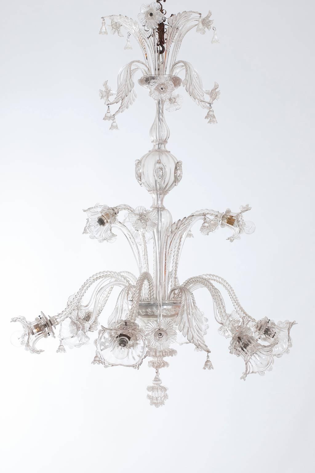 Elegant Italian Venetian chandelier in Murano glass in the style of Galliano Ferro, circa 1920s, having elegant six arms look down and three arms look up, with beautiful leafs and flowers look up and down, in the middle part is composed of two stems