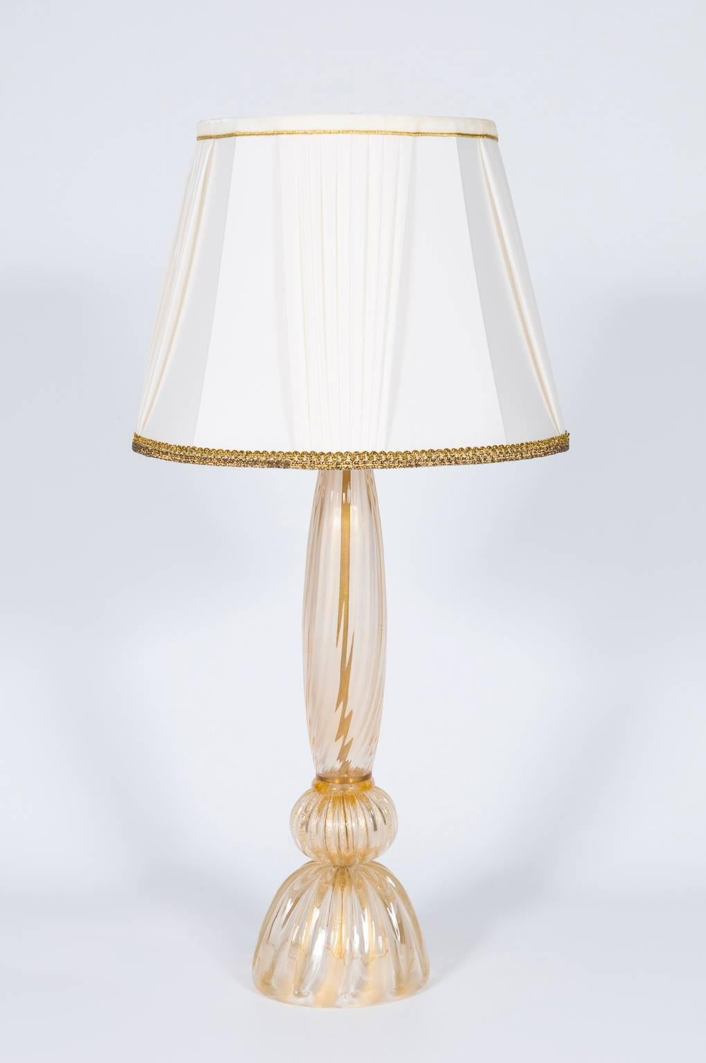 Handcrafted Gold Italian table lamp in Murano glass, composed from a gold striped base with above a sphere and from a gold striped stem, with one light over. The Table lamp is in very excellent original condition, made circa 1980s.
We can