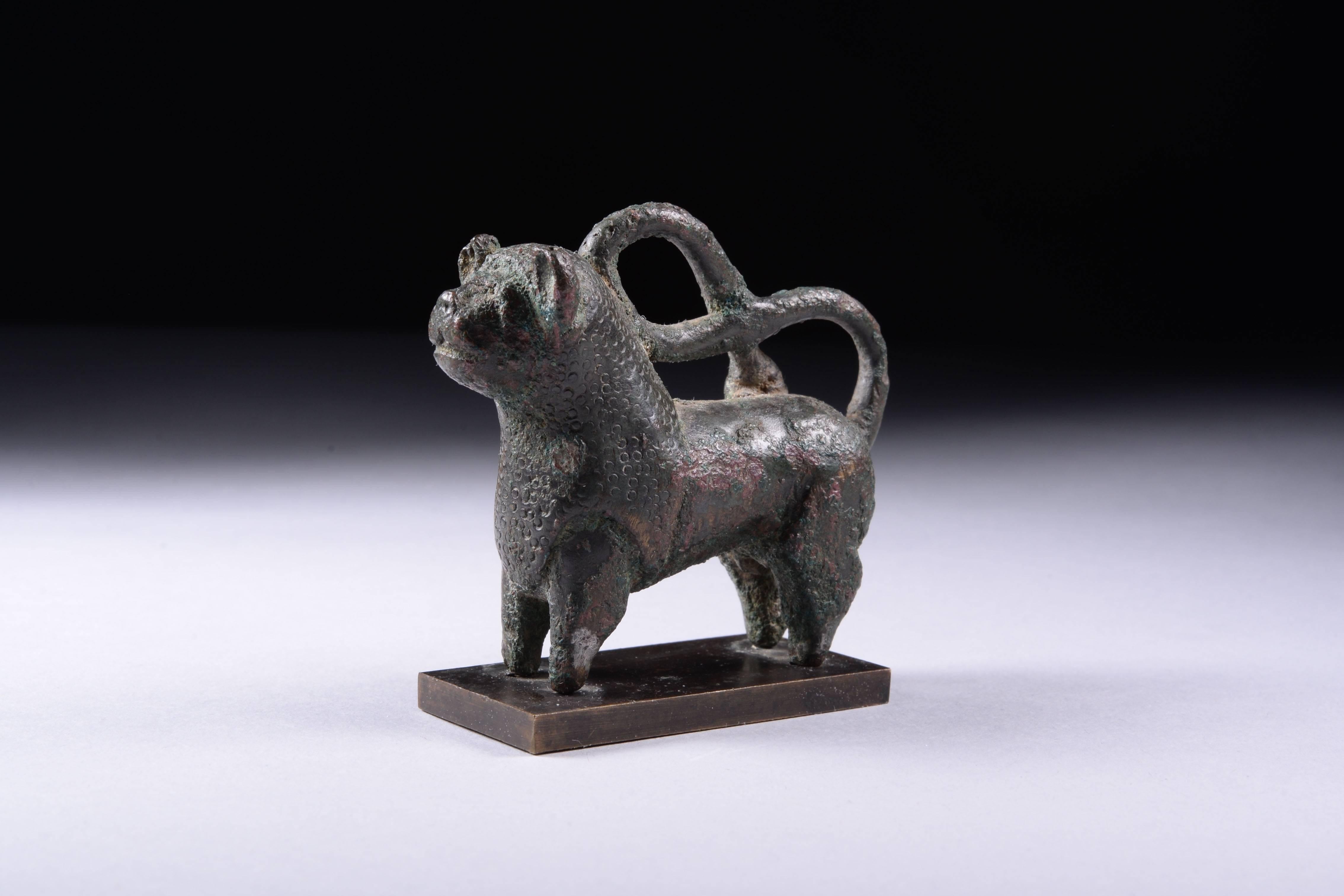 An unusual ancient Islamic bronze lion, possibly Seljuk, dating to the 11th century AD. A well modelled piece, bursting with character, the lion standing foursquare with his long tail curled back on itself in a double loop. With anthropomorphic